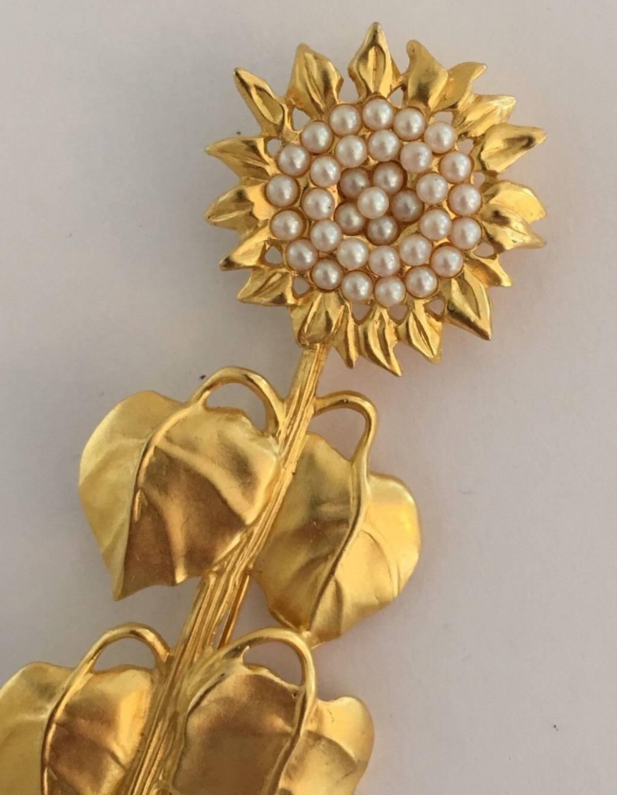 Rare Vintage Karl Lagerfeld Brooch featuring a Beautiful Matte Gold Sunflower accented with Glass Pearls. Measuring Approx. 3.5” Signed: KL. A perfect complement to every wardrobe… Illuminating your Look with a touch of class!
