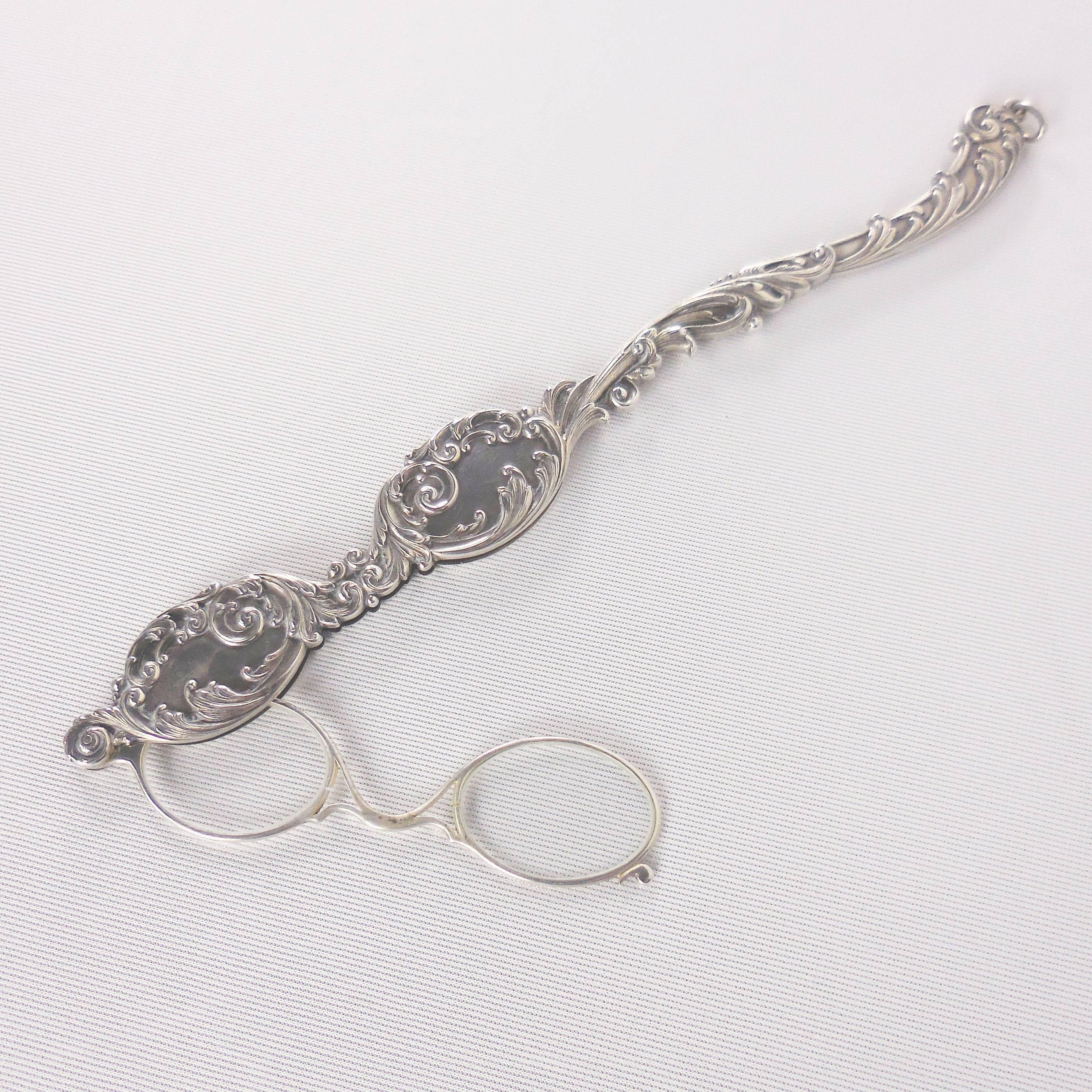 Long ornate sterling siver Art Nouveau retractable Lorgnette pendant featuring ornate repoussé volute decorations on the handle. Hand-crafted with exceptional workmanship.
Approximate total weight= 54.4grams. Circa 1900.