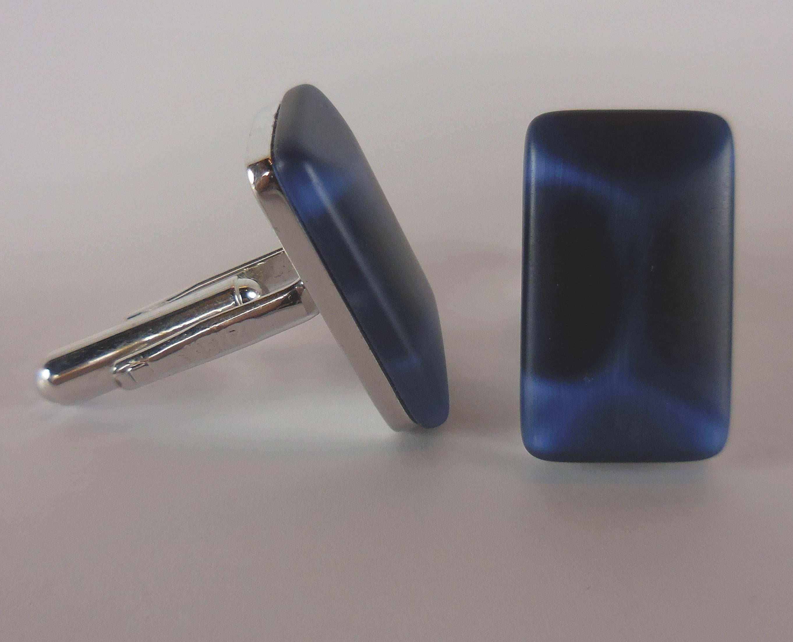 Pair of luminous faux Blue Tiger eye Stone cuff links with signature embossed T-bar fastenings in polished silver finish by Kenzo.
Signature presentation box included.