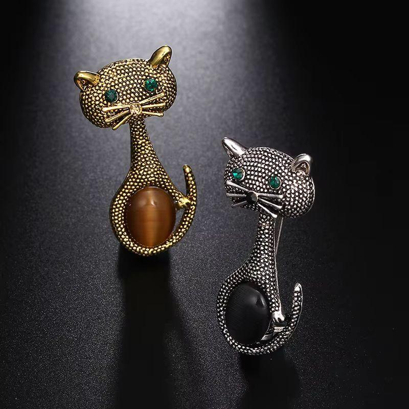 Semplicemente delizioso! Bellissima coppia di spille vintage con gatto dagli occhi verdi. Accentuato da pietre finte incastonate a mano. Montaggio squisitamente dettagliato in tonalità oro e argento con texture a ciottoli. Più Meraviglioso in tempo