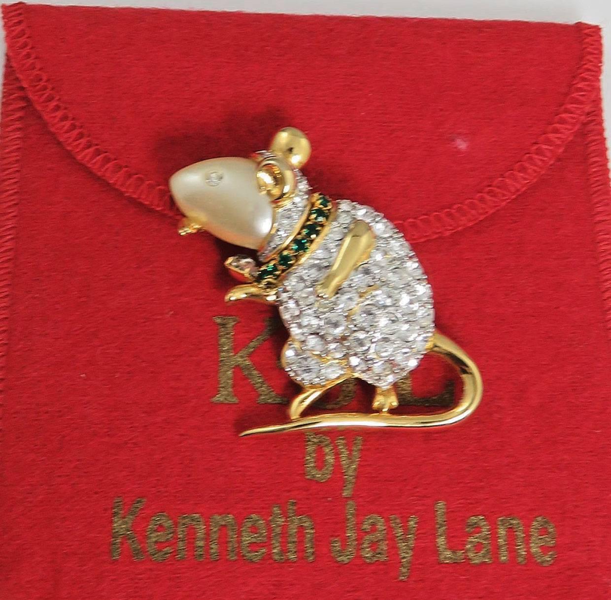 Wonderful KJL Mouse Brooch; Faux South Sea Pearl body, enhanced with sparkling green and white Swarovski crystals; original red pouch included.  
