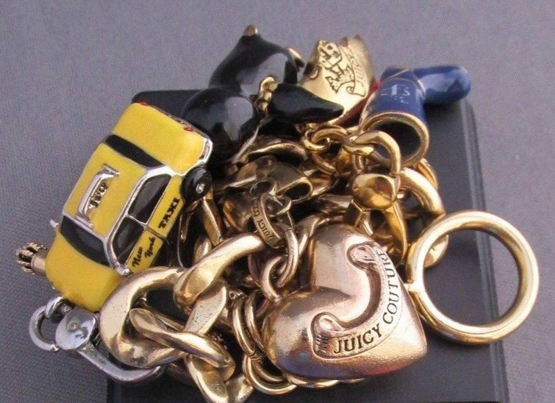 Fabulous Juicy Couture Gold Tone Link 3D Charm Bracelet suspending 5 3D Gold tone and Enamel Charms depicting an enamel Penguin, Heart, enamel Taxicab, enamel Boot and JC Emblem; approx. 8.25 inches Long. Add your own Style and Pizzazz to any