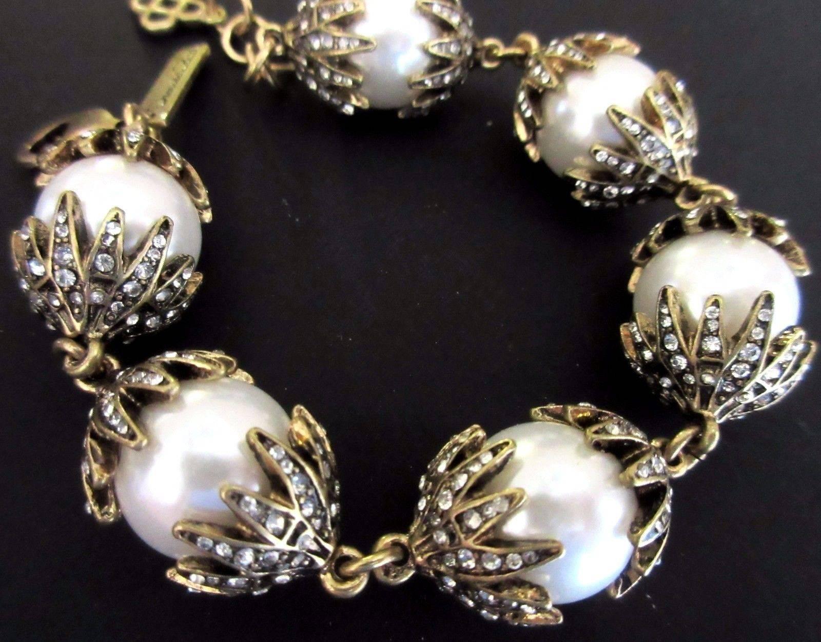 Beautiful Oscar De La Renta Runway Bracelet, comprising Faux Pearl Crown capped Sparkling Crystals. Signed with script Signature hang tag and Iconic Fleur de Lis Charm; Approx. 8 inches long. Add your own Chic Style and Pizzazz to any outfit! 
