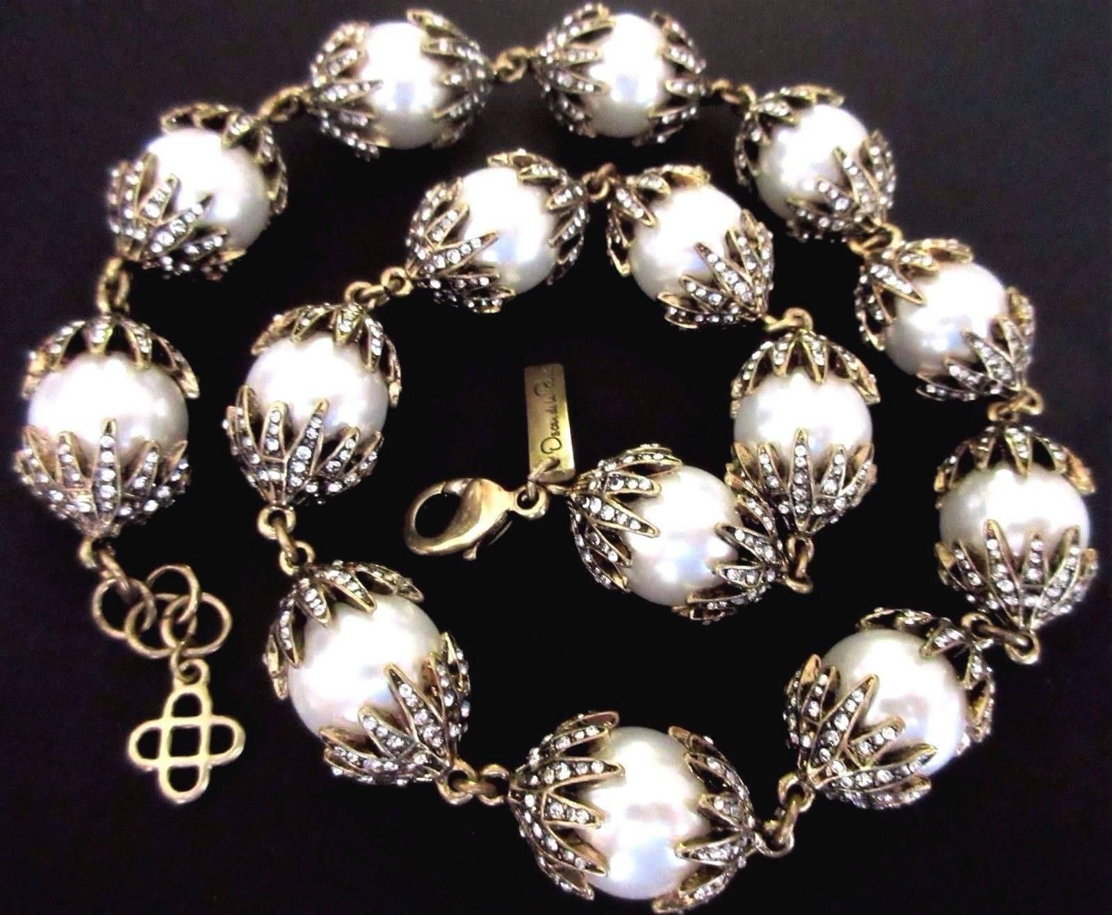 Beautiful Oscar De La Renta signed Runway Necklace, comprising Faux Pearl Crown capped Sparkling Crystals. Signed with script Signature hang tag and Iconic Fleur de Lis Charm; Approx. 22 inches long. Add your own Chic Style and Pizzazz to any