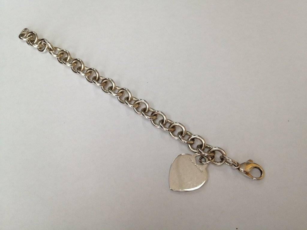 Tiffany & Co. Sterling Silver Link Bracelet with dangling Heart. Marked: Tiffany & Co. 925 Approx. Length: 7 inches; Tiffany & Co. Box included. Classic and Timeless…A great addition to your collection! 
