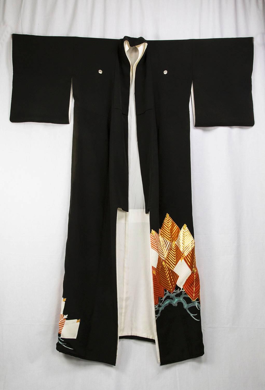 A Striking Japanese formal Black Silk Woman's Kimono (or Tomesode) , of the late Showa period, dyed with five Mon or family seals on the center back, front shoulders, and back sleeves. The Kimono is elegantly resist-dyed along the lower body with