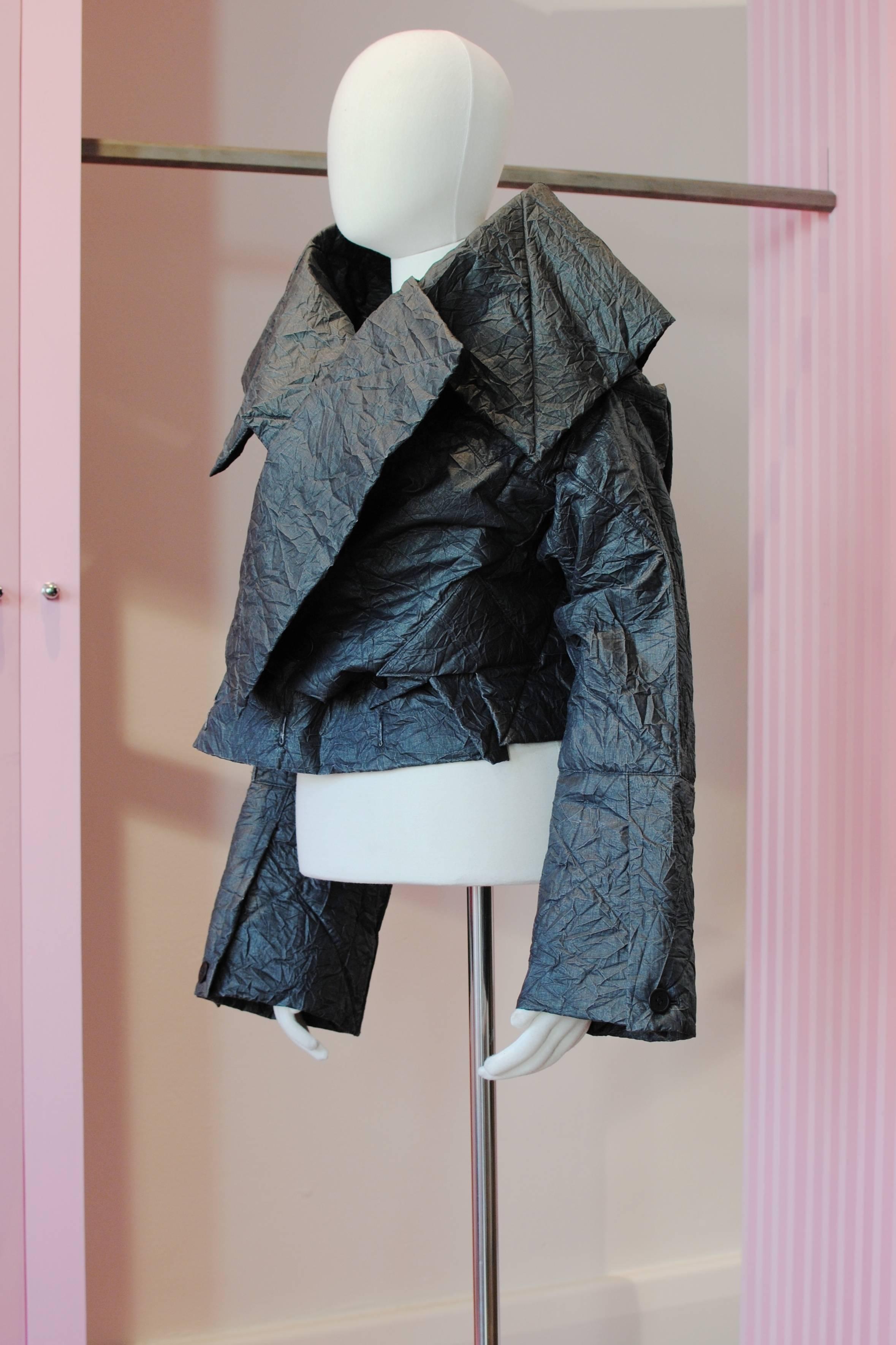 Issey Miyake black crinkle origami jacket from the 1998 Autumn/Winter collection. It features stiff creased fabric with polyester batting , two waist pockets and is designed to also be worn upside down for a different look.

Size —