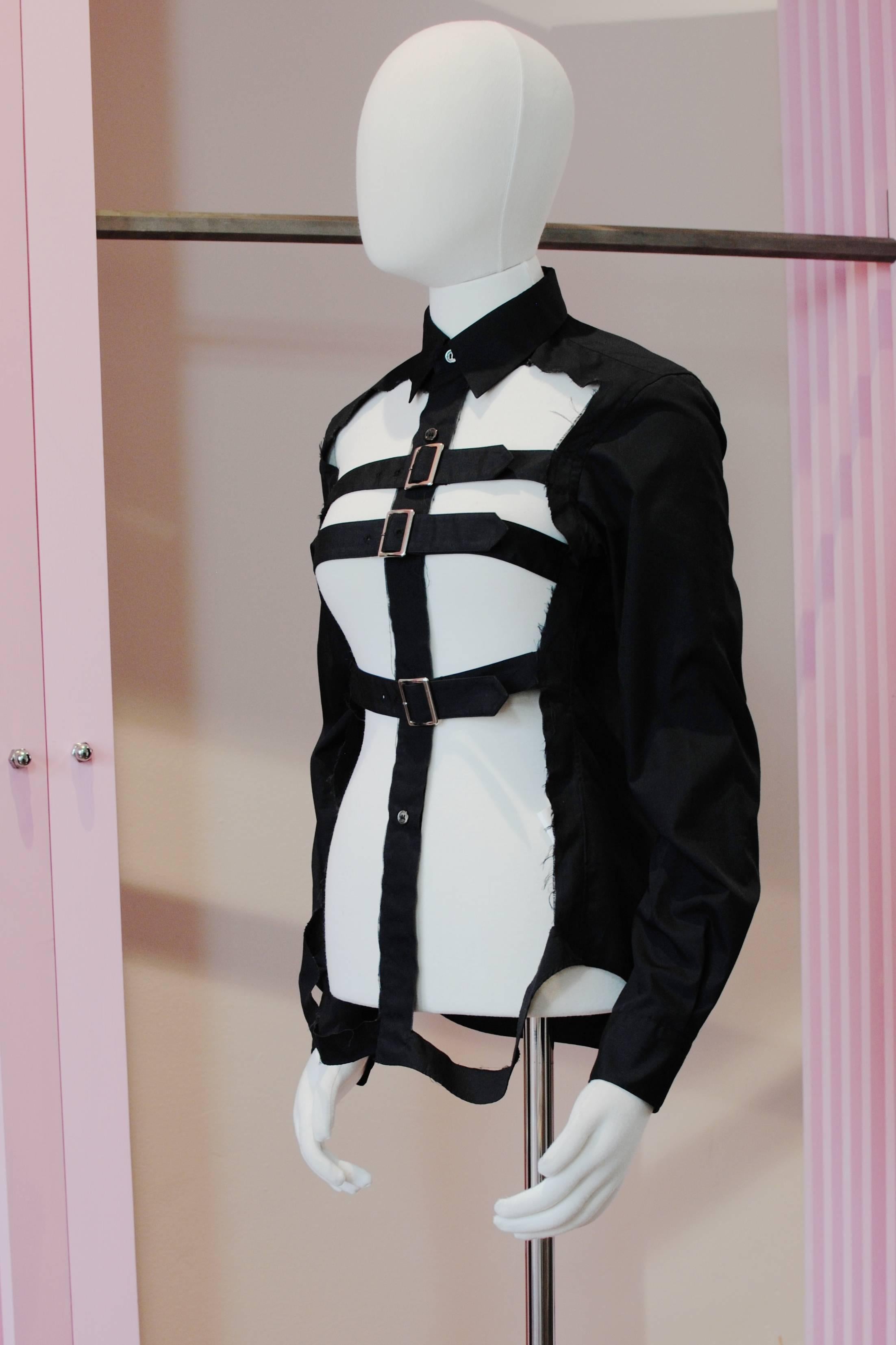 COMME des GARÇONS black cut-out cage shirt from the 2008 Autumn/Winter collection. It features a classic collar, full length sleeves and buckle fastening.

Size — Small
Shoulder — 39 cm
Chest — 40 cm
Sleeve — 60 cm
Length — 70 cm 

Material