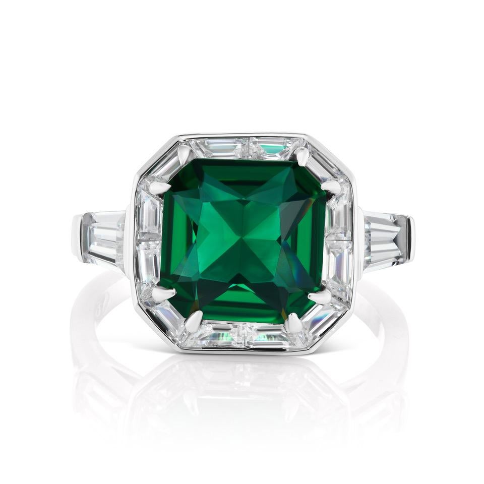 Magnificent Costume Jewelry Art Deco Style Square Man-Made Flawed Emerald Cubic Zirconia Diamond Halo Style Silver Ring Bordered with Cubic Zirconia Fancy-Cut Baguettes and Tapers on the Shank. 
Center 'emerald' looks a like a 5 carat, bright and