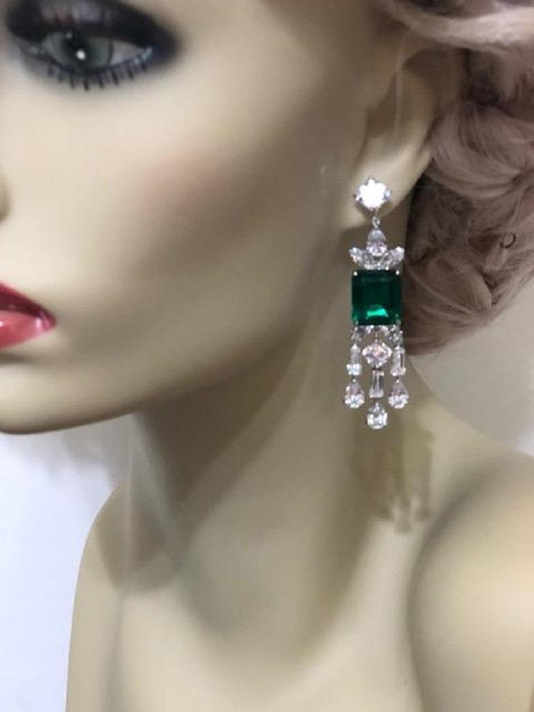 A pair of stunning faux synthetic emerald and white cubic zirconia sterling earrings.
The intense emerald color  stones are equivalent to 8 carats surrounded by bright white cubic zircons all set like the finest real diamond jewelry.
21/2'' long  x