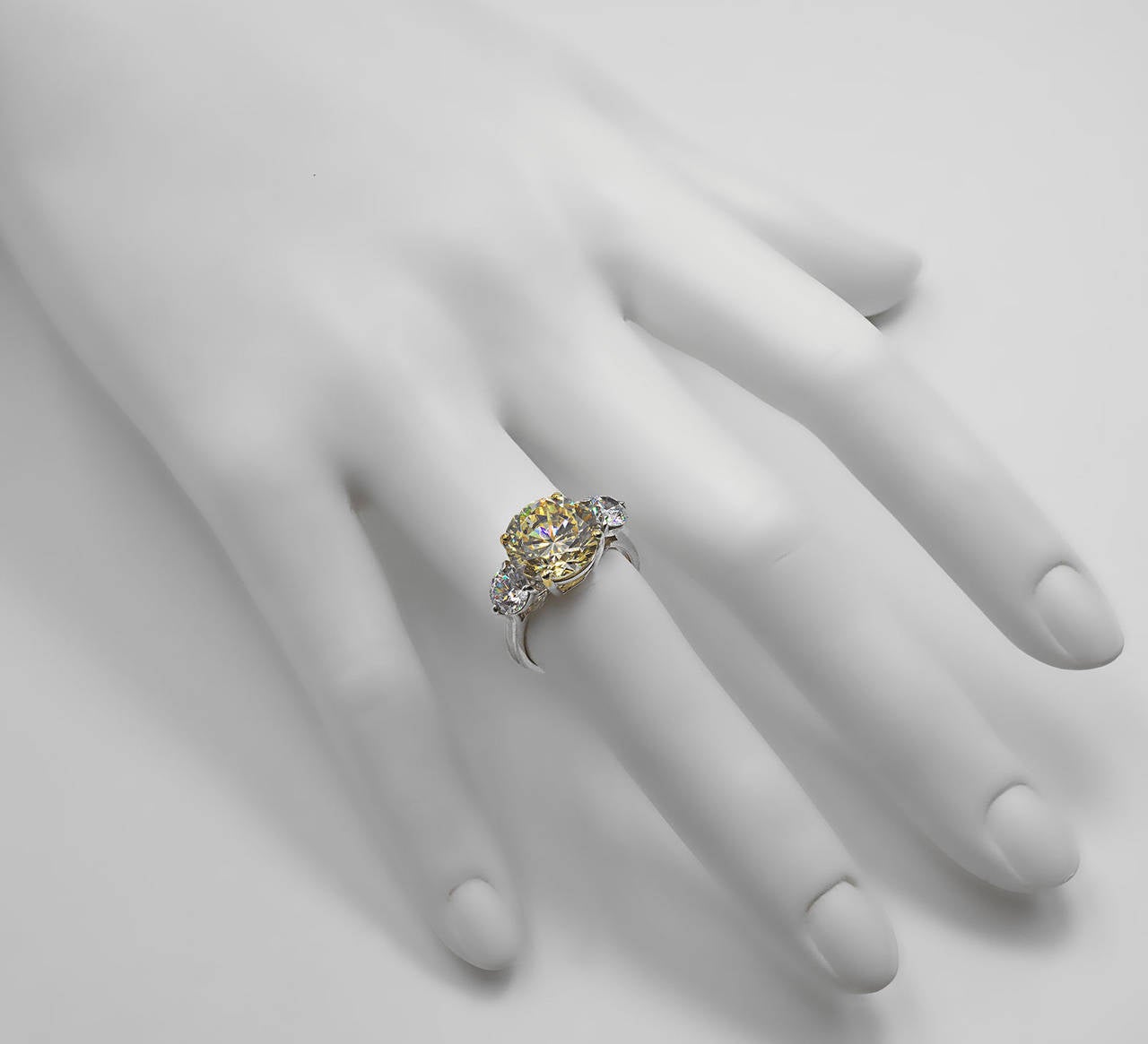 Wonderful brilliant faux canary and white diamond trinity ring made of hand cut cubic zircons and white gold. 

The centre stone is the equivalent size of a 4 carat canary diamond and the white side stones are 25 points of a carat each.

