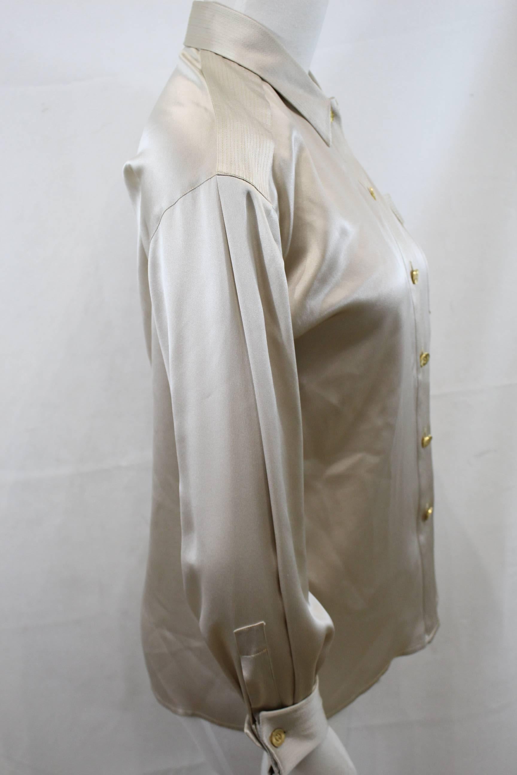 Really nice Chanel Silk blouse form é009 cuirse collection. 

Goldne buttons. 

Cuff closed with a pair of cufflinks.
Fair  condition, some micro stains in the upper part and in armpits, thats why the low price

Size 44 french