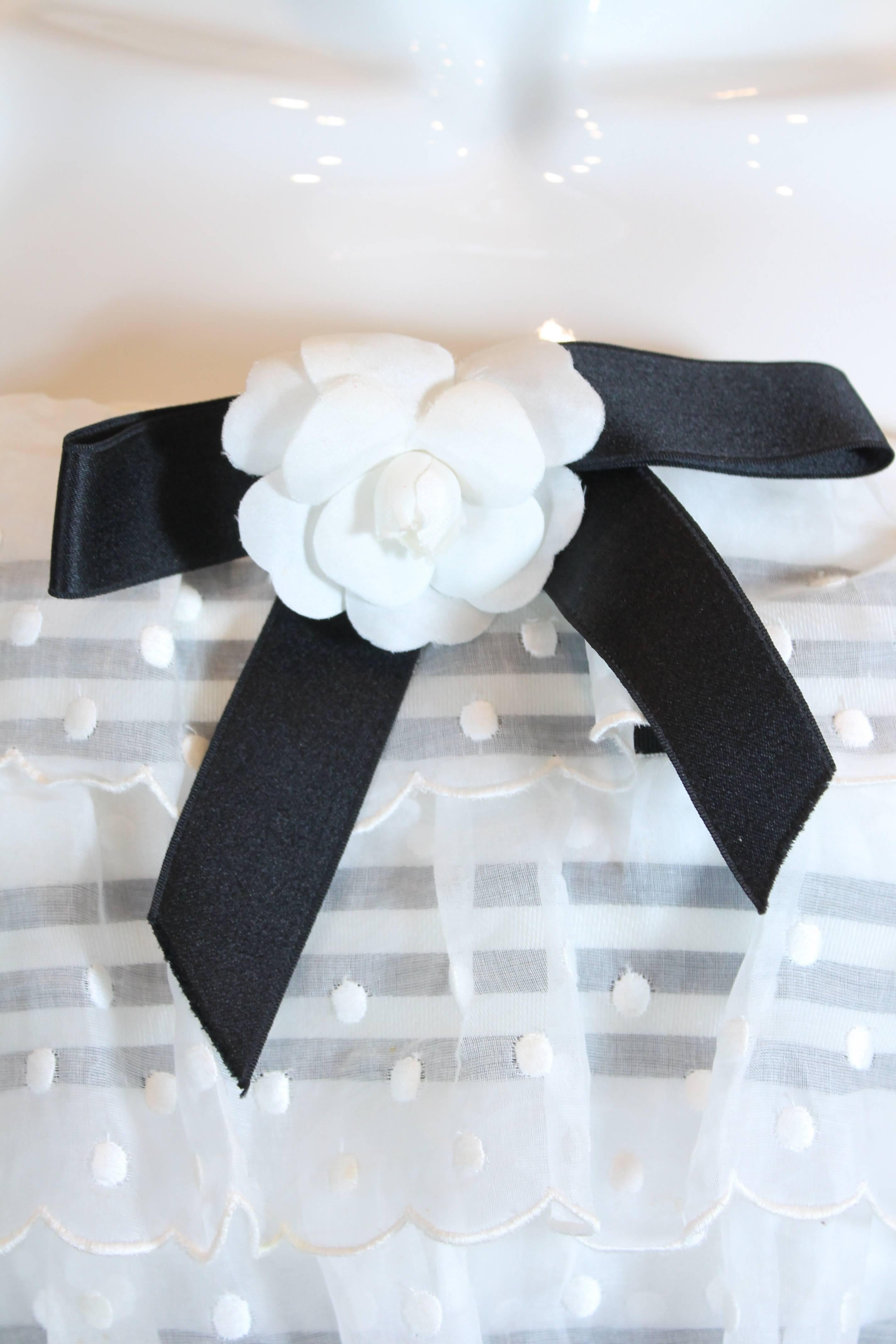 No one would believe this Vintage Chanel dress was from the 1980's. The black cotton pleated body is topped with a girly tiered dotted swiss fabric layering and a black/ivory striped grosgrain ribbon panel. Additional detachable black and ivory