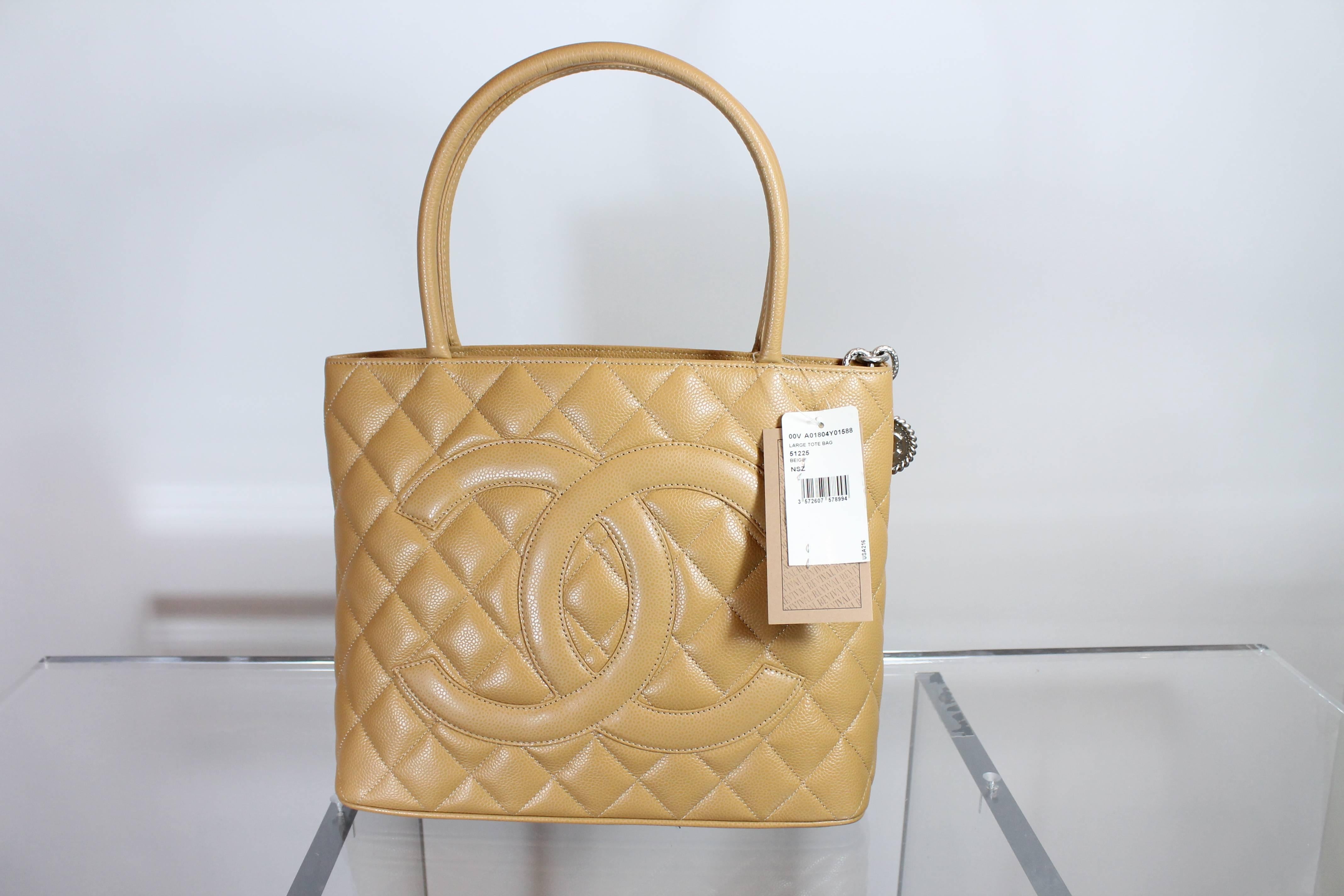 Brand New and desirable Chanel classic medallion tote bag in neutral beige quilted caviar leather. Rich gold-tone hardware, dual rolled top handles, single exterior pocket, tonal leather interior, dual pockets; one with zip closure at interior walls