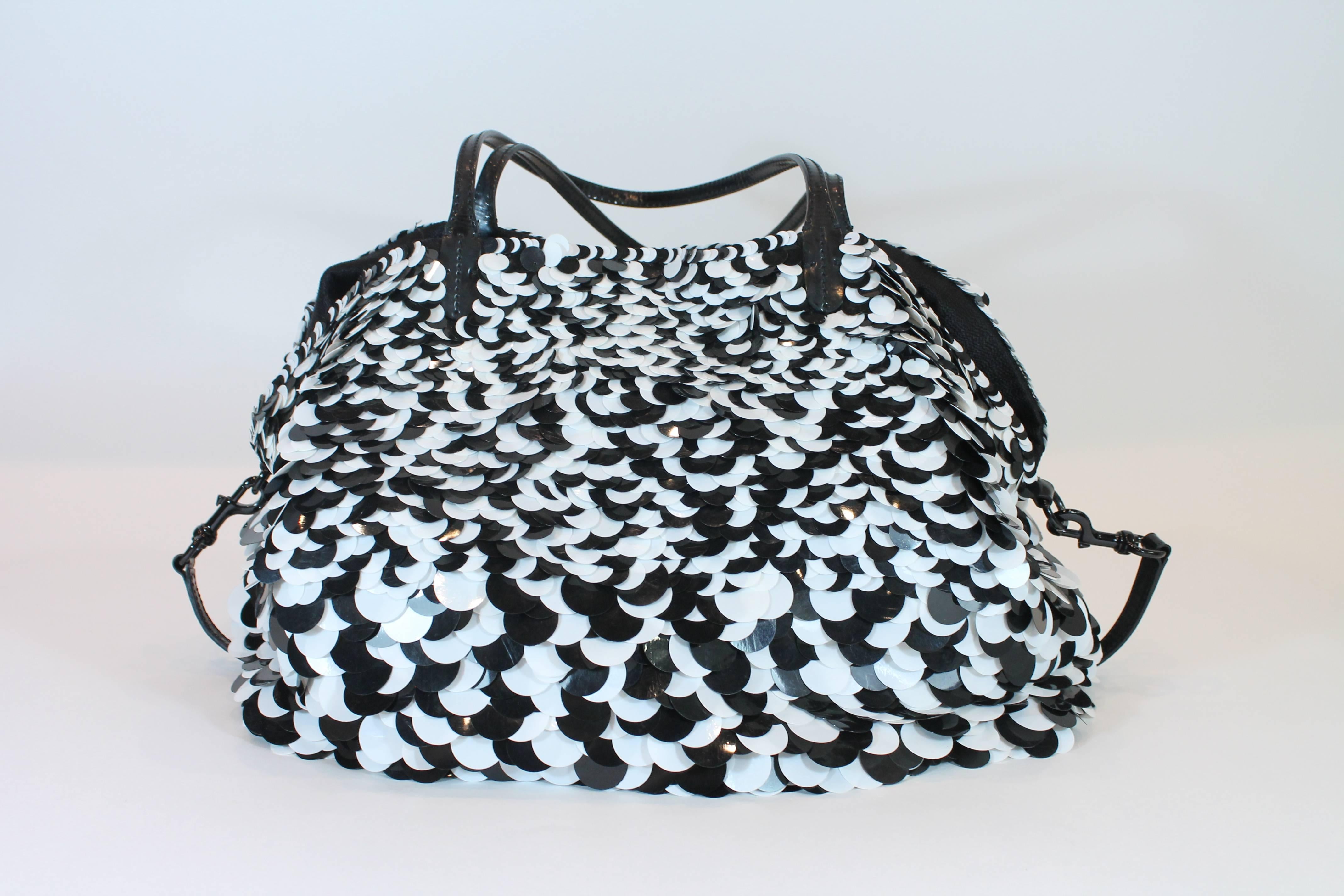 Black and white sequins in a variety of sizes.
Patent leather trim.
Dual top handles and removable shoulder strap.
Magnetic button closure.
One interior zippered pocket.
