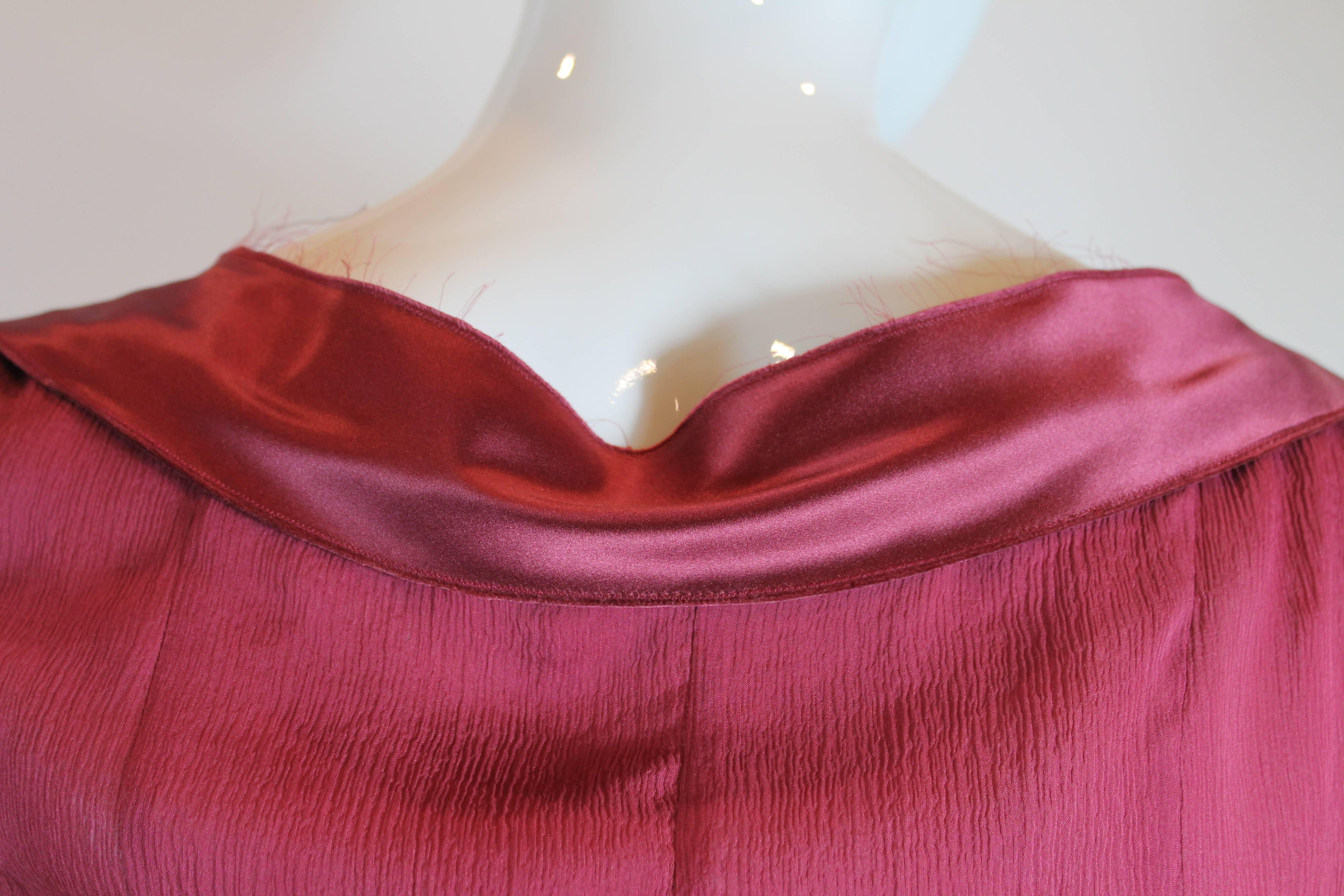 The beauty of Prada is in the details. This burgundy silk dress has the perfect combination of simplicity and style. Chiffon body trimmed in silk trim and bow. Nude mesh peeks out of front bow - black beaded applique. Hidden side zipper. Size 42.