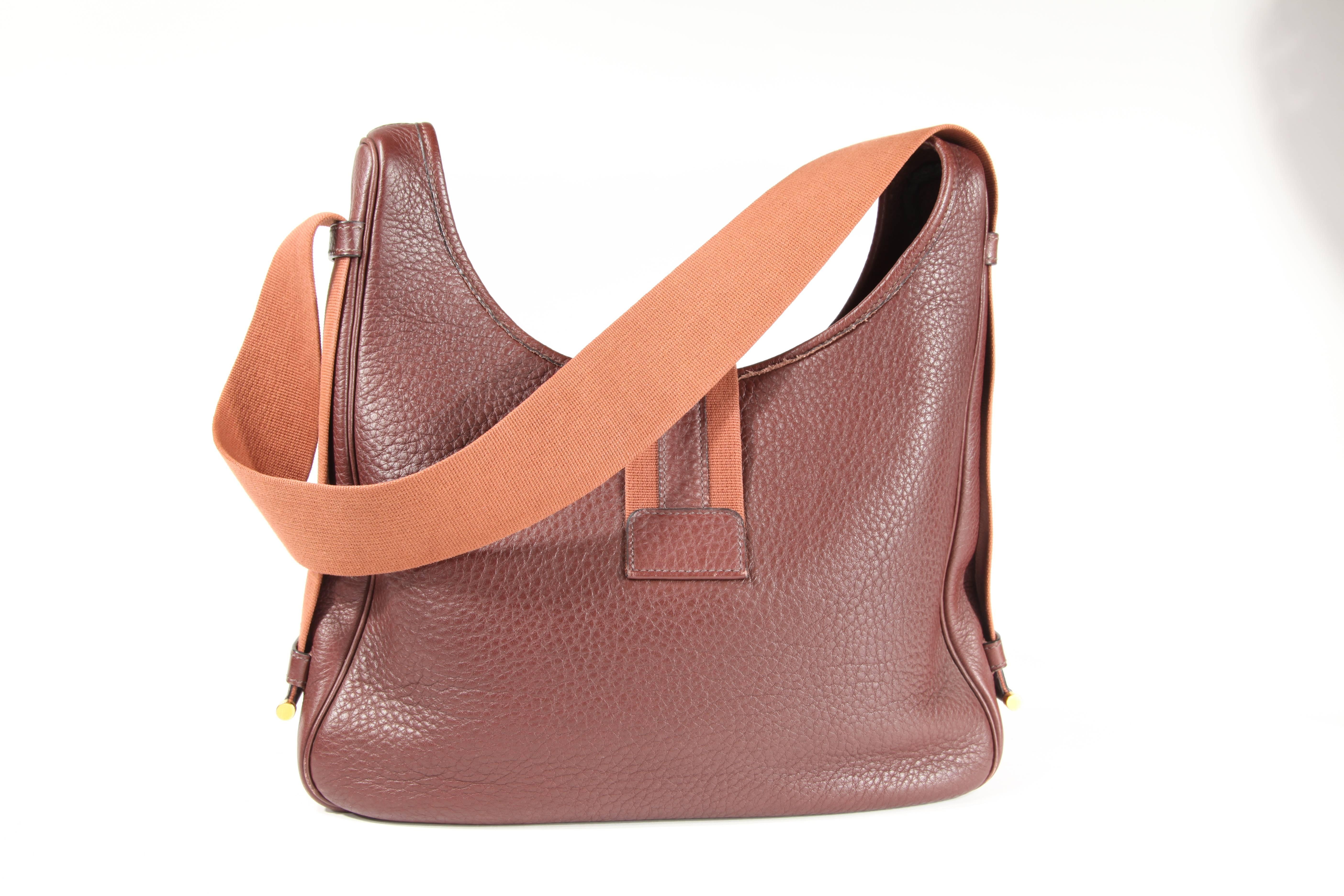 This Hermes bag features brown togo leather with a light brown canvas adjustable shoulder strap. The canvas strap is adjustable which allows the bag to be worn on the shoulder or across the body. This bag has gold-tone hardware with a button