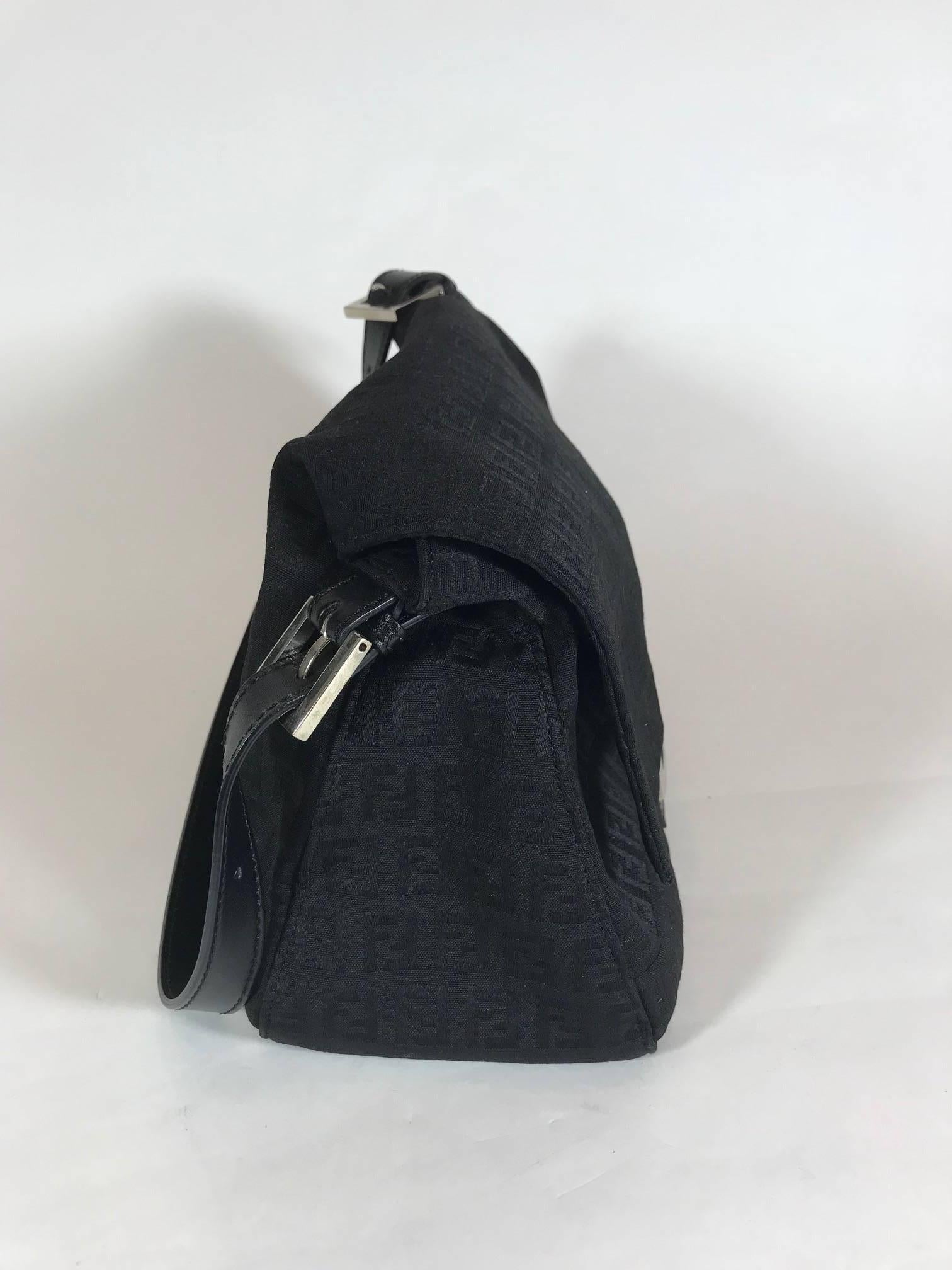 Black canvas. Silver-tone hardware. Tonal leather trim. Single flat shoulder strap. Tonal jacquard woven lining. Single zip pocket at interior wall and snap closure at front flap. Dust bag included.