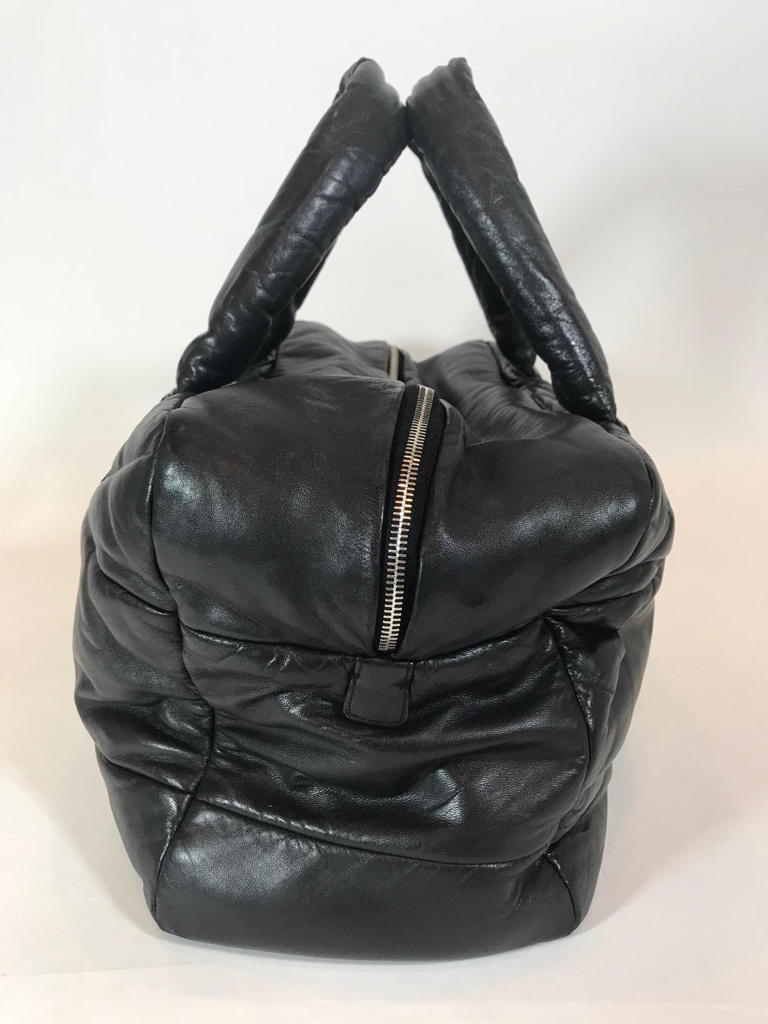 Black quilted leather Chanel Coco Cocoon tote with silver-tone hardware, dual rolled shoulder straps, burgundy quilted leather lining, single interior zip pocket and two-way zip closure at top. Estimated Retail: $2,300