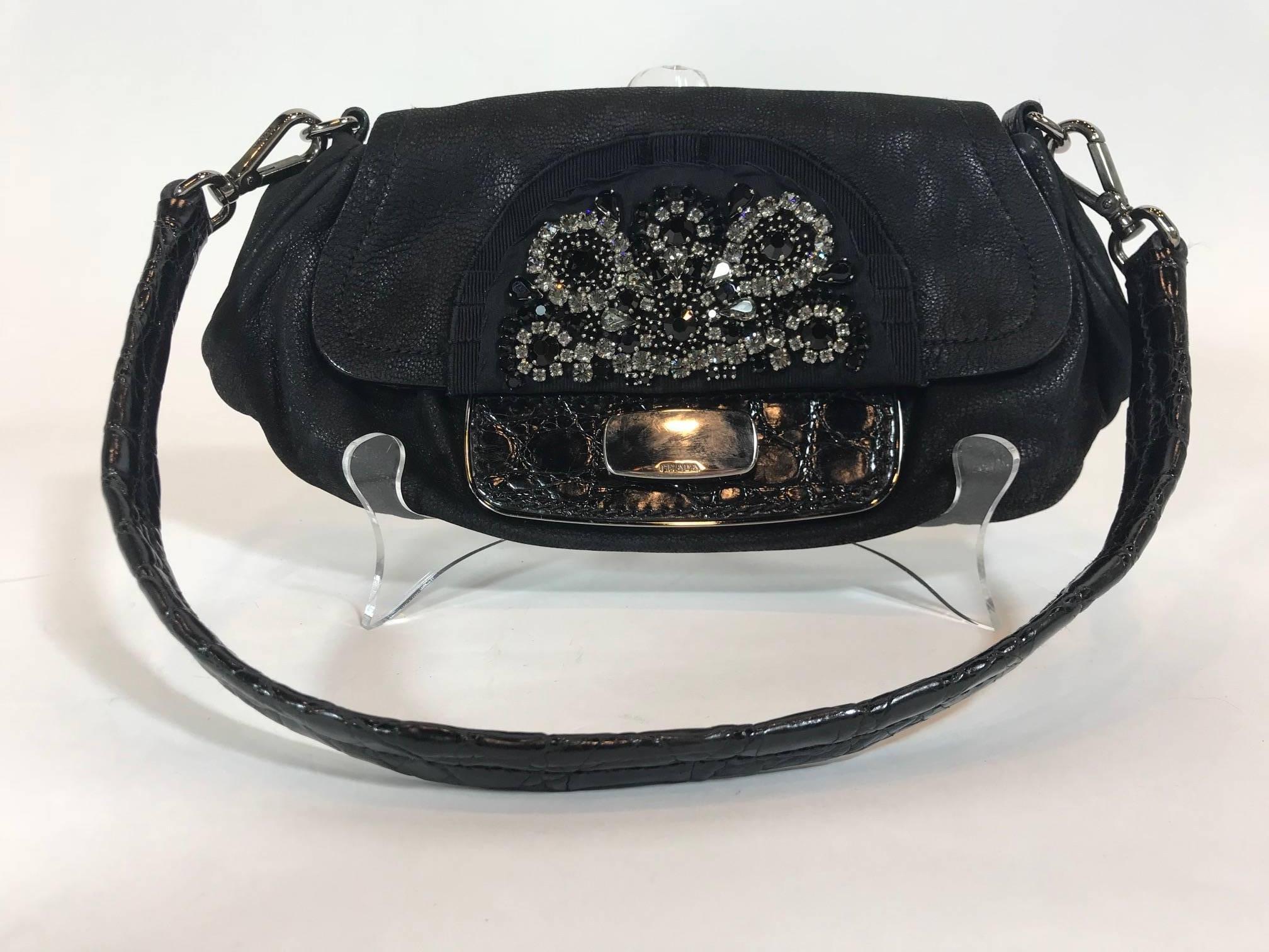 Black leather nubuck. Silver-tone hardware. Front flap with push lock closure. Removable flat shoulder strap. Jeweled embellishments at front. Tonal jacquard lining. One interior zip pocket.