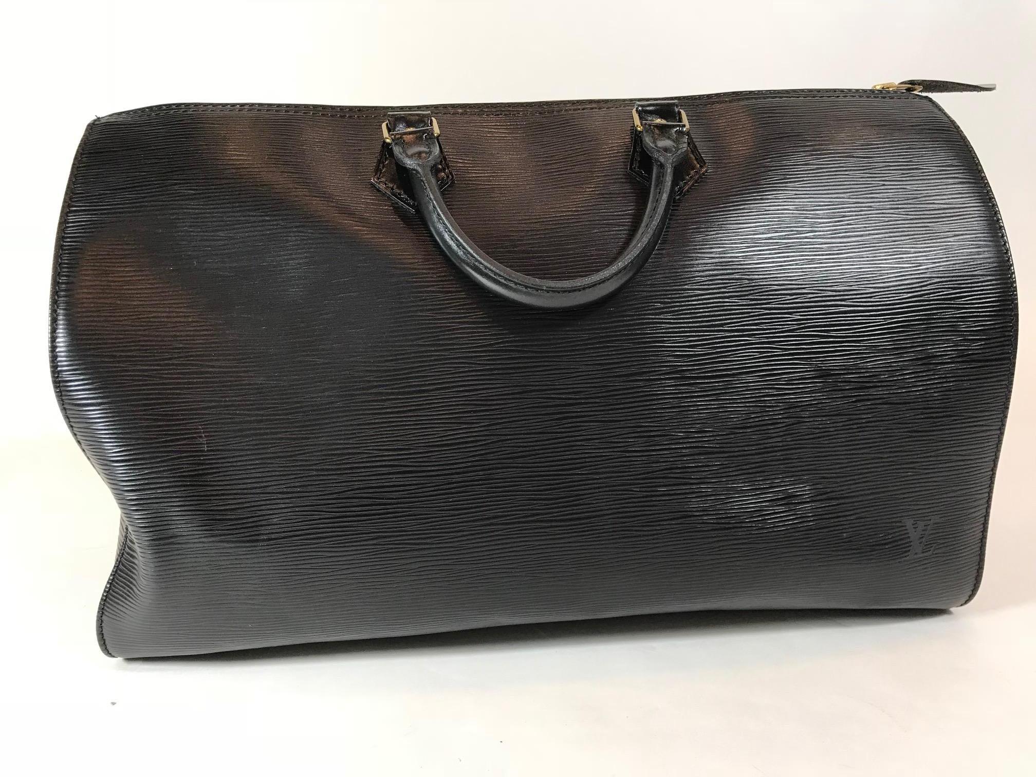 Black Epi leather Louis Vuitton Speedy 40 with silver-tone hardware, dual rolled top handles, single slit pocket at side, tonal canvas lining, dual slit pockets at interior wall and zip closure at top.
