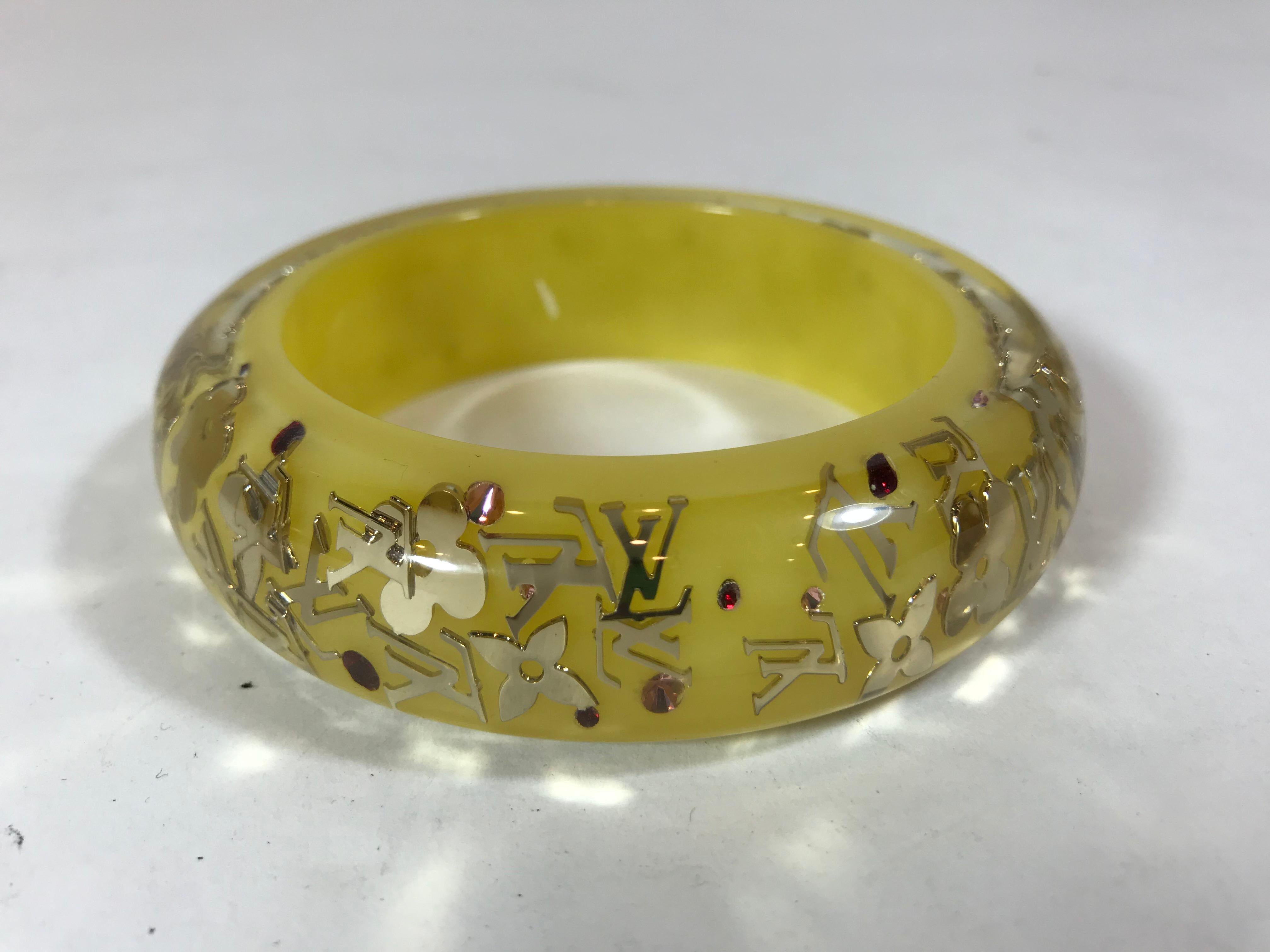 Yellow and clear resin. Silver-tone monogram details and red and pink crystal embellishments.