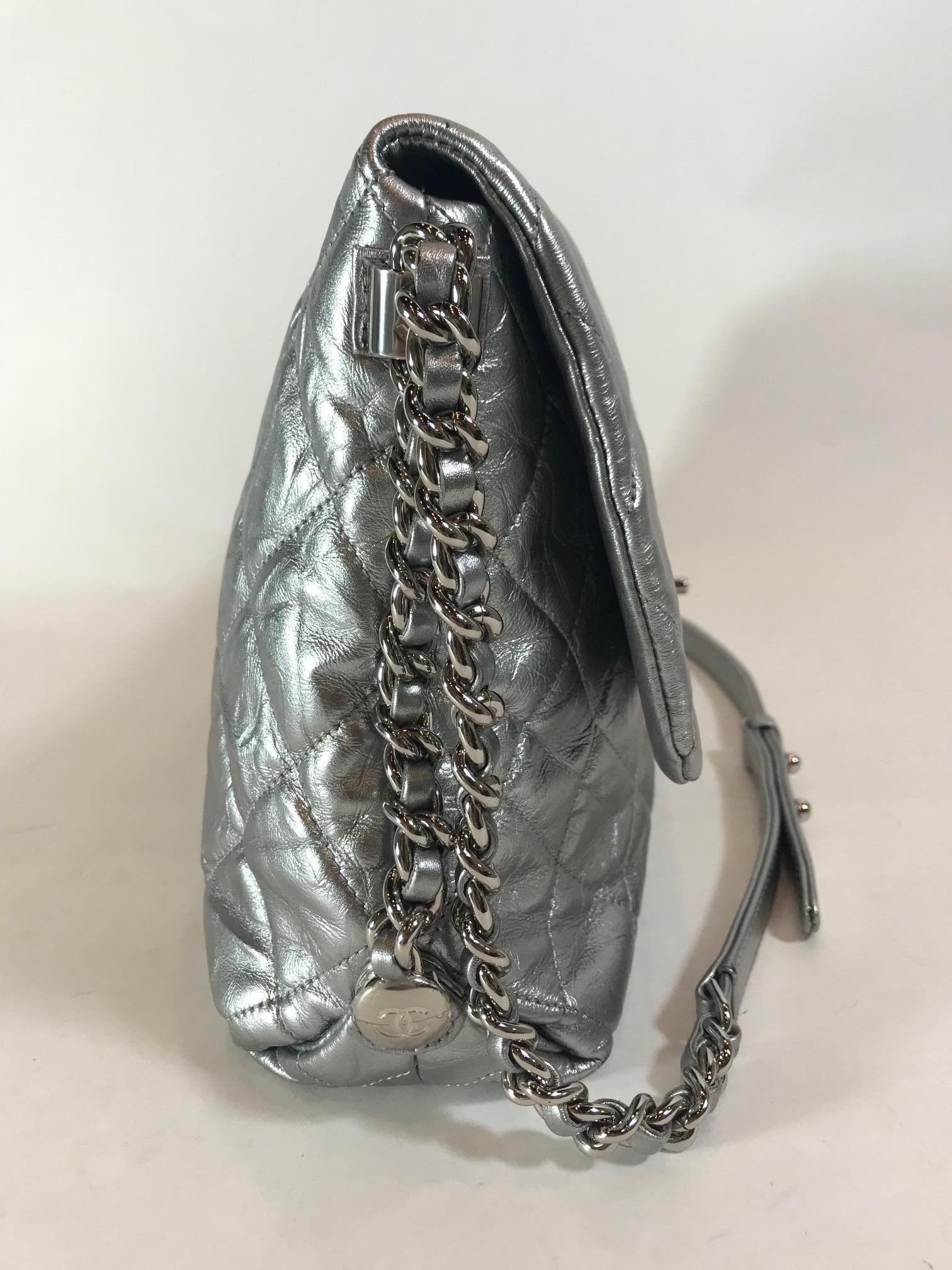 Silver metallic quilted calfskin leather. Silver-tone hardware. Front flap closure with 