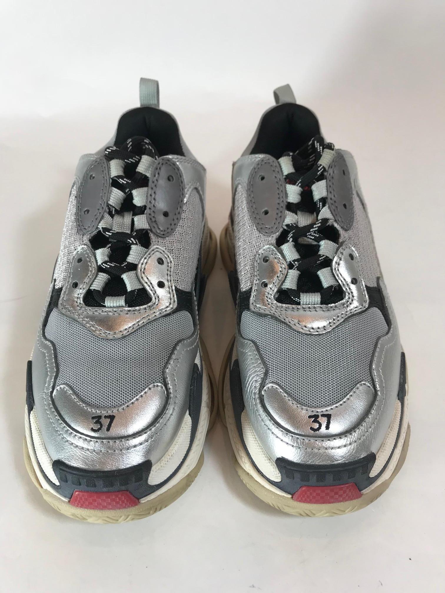 From Current Collection. Metallic silver leather and taupe mesh Balenciaga Triple S trainers with reflective panels at counters, embroidered logo at sides, lace-up closures at uppers and rubber soles.