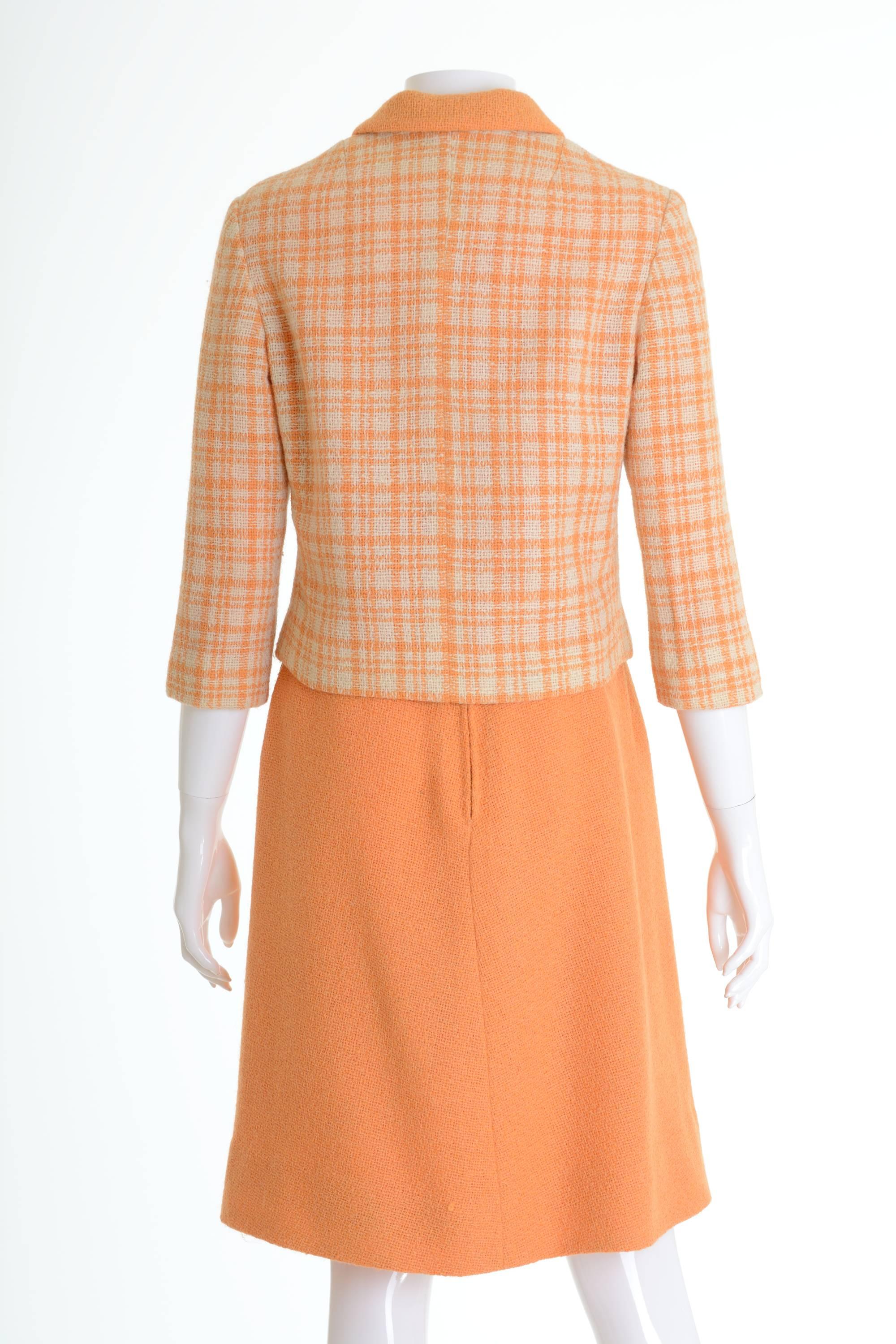 This lovely 1960s suit set by Italian couturier Sorelle Fontana is in orange and cream plaid printed woolen fabric. The jacket has plastic buttons closure, 3/4 sleeves and is fully lined. The skirt has back zip closure and is lined. 

Very good