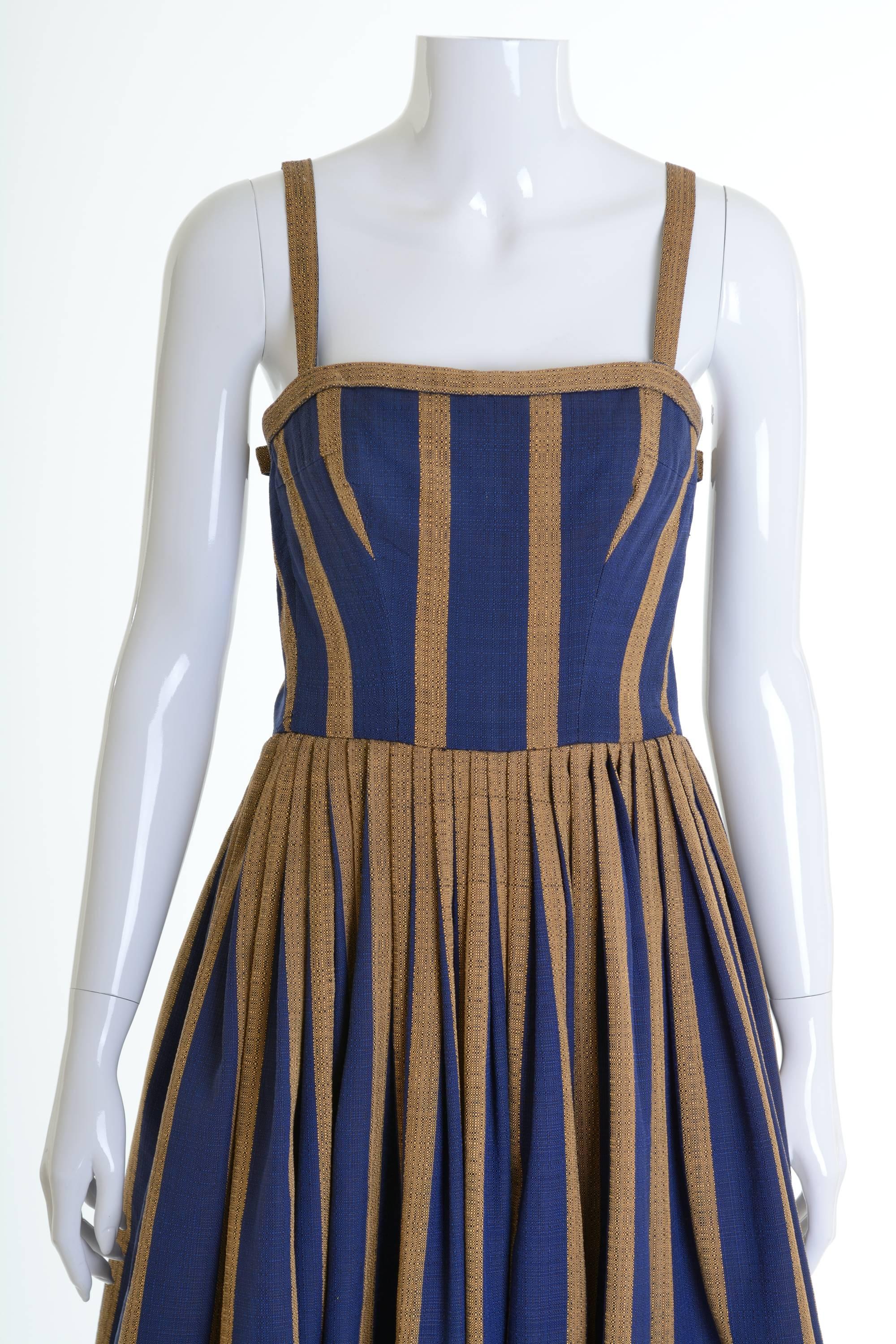 This 1950s spaghetti strap dress has a bustier in the inside and a circle pleated skirt.
The skirt is fully lined and has bows. The zip closure is behind and it has also covered eyelets & washers and hook & eye closures in some parts of the