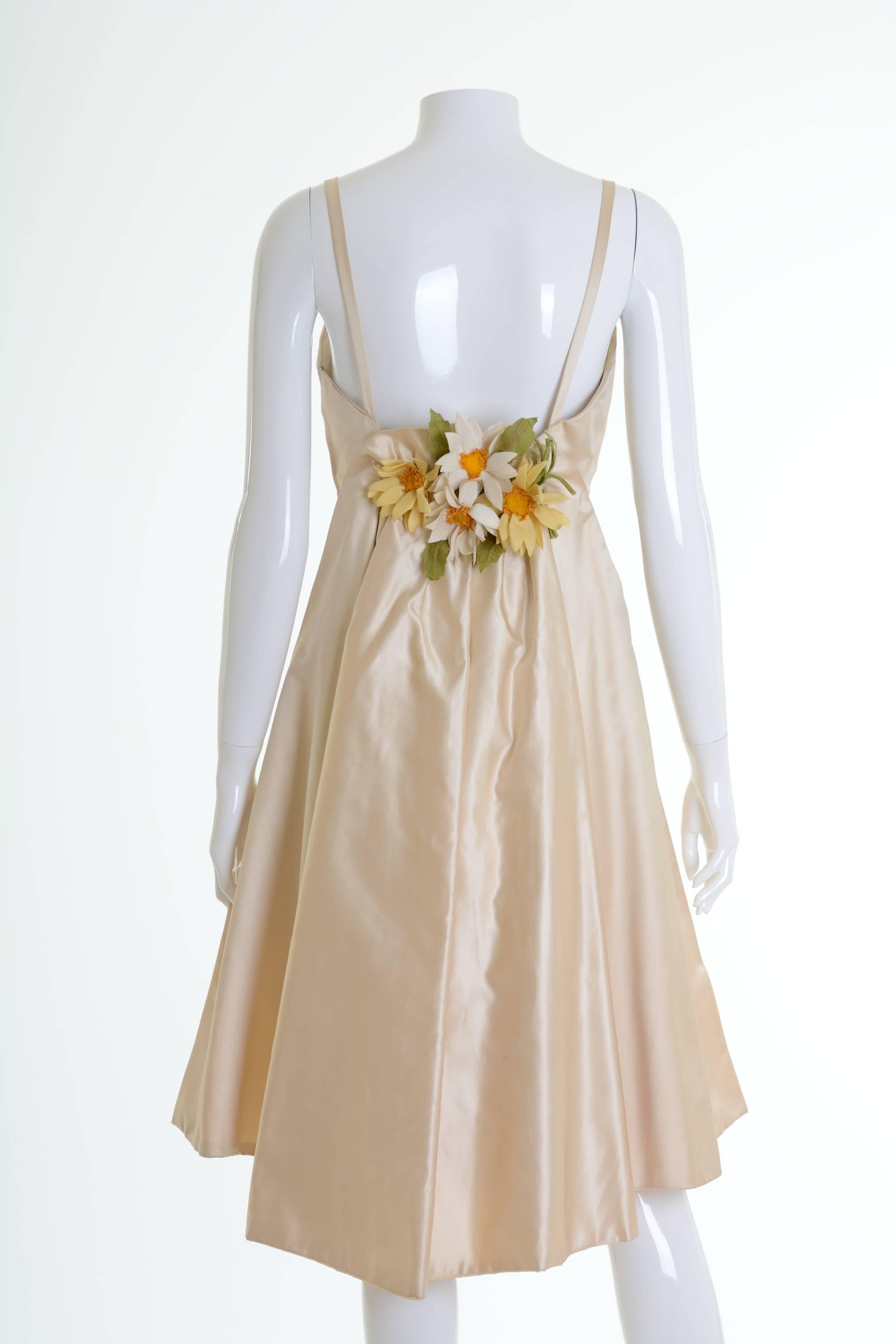 This amazing 1950s cocktail dress is in a cream silk taffeta fabric with lovely flowers on the back. It has boning corset, spaghetti straps, pleateds skirt and side zip closure. 

Good vintage condition
 
Label: N/A
Fabric: silk taffeta
Color:
