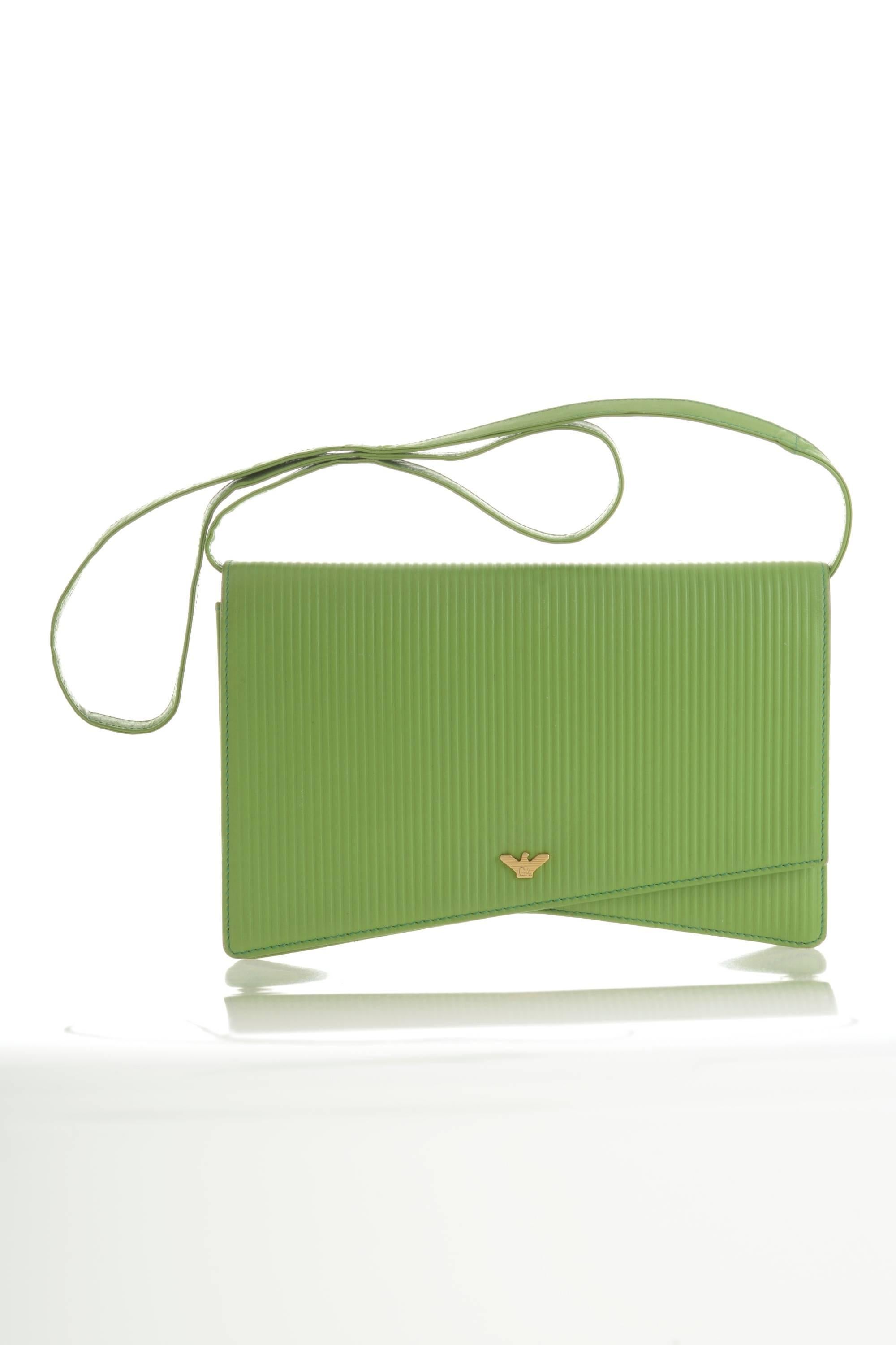 This lovely Giorgio Armani clutch shoulder bag is in a apple green striped printed leather with golden metal Logo detail. It has removable shoulder strap and snap closure.
With strap for easy cross body or shoulder bag.
It's perfect for any