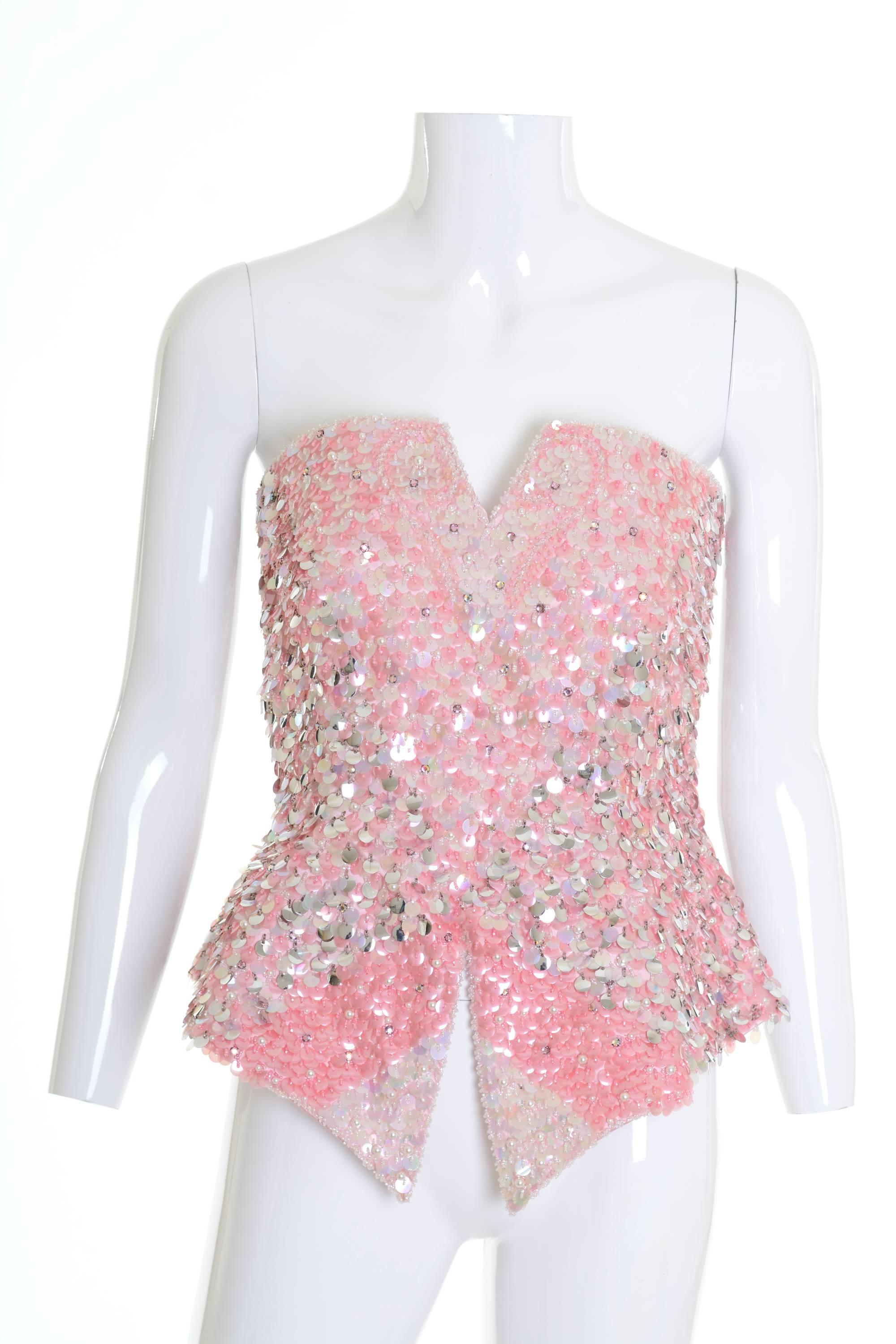 1980s bustier in a silk satin fabric covered with white, pink and silver sequins and seed beads, fully lined, boned bodice, side zip closure. 

Excellent Vintage Condition

Label: unknown
Fabric: silk
Colors: white, pink ,