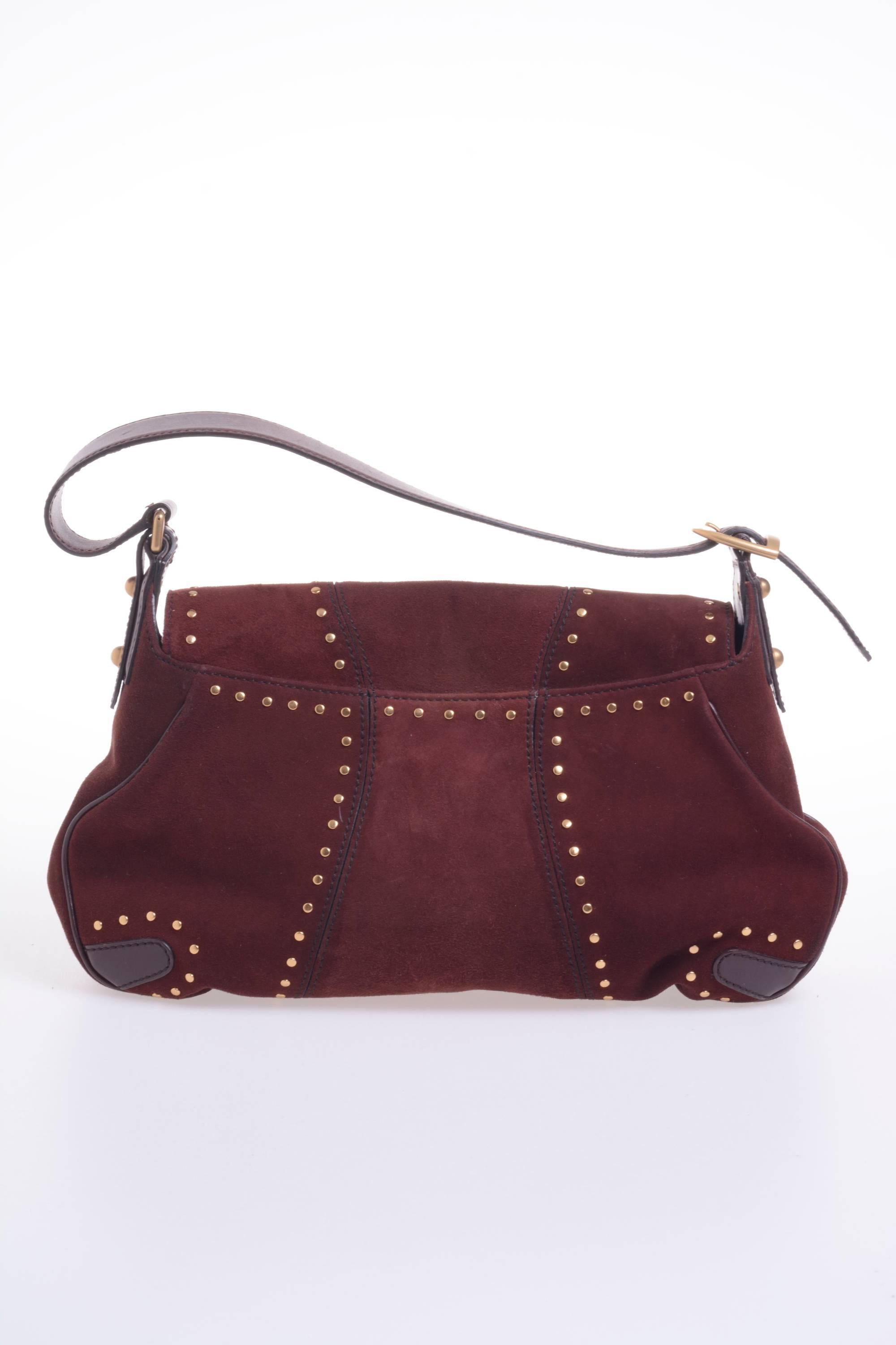 GUCCI Leather Bordeaux horsebit shoulder bag, with decorative gold studs and frontal gold horsebit and chained closure, Hourglass cuts in front and back, adjustable handles, It has leather lining with a zip pocket inside. Made in Italy. 

Style