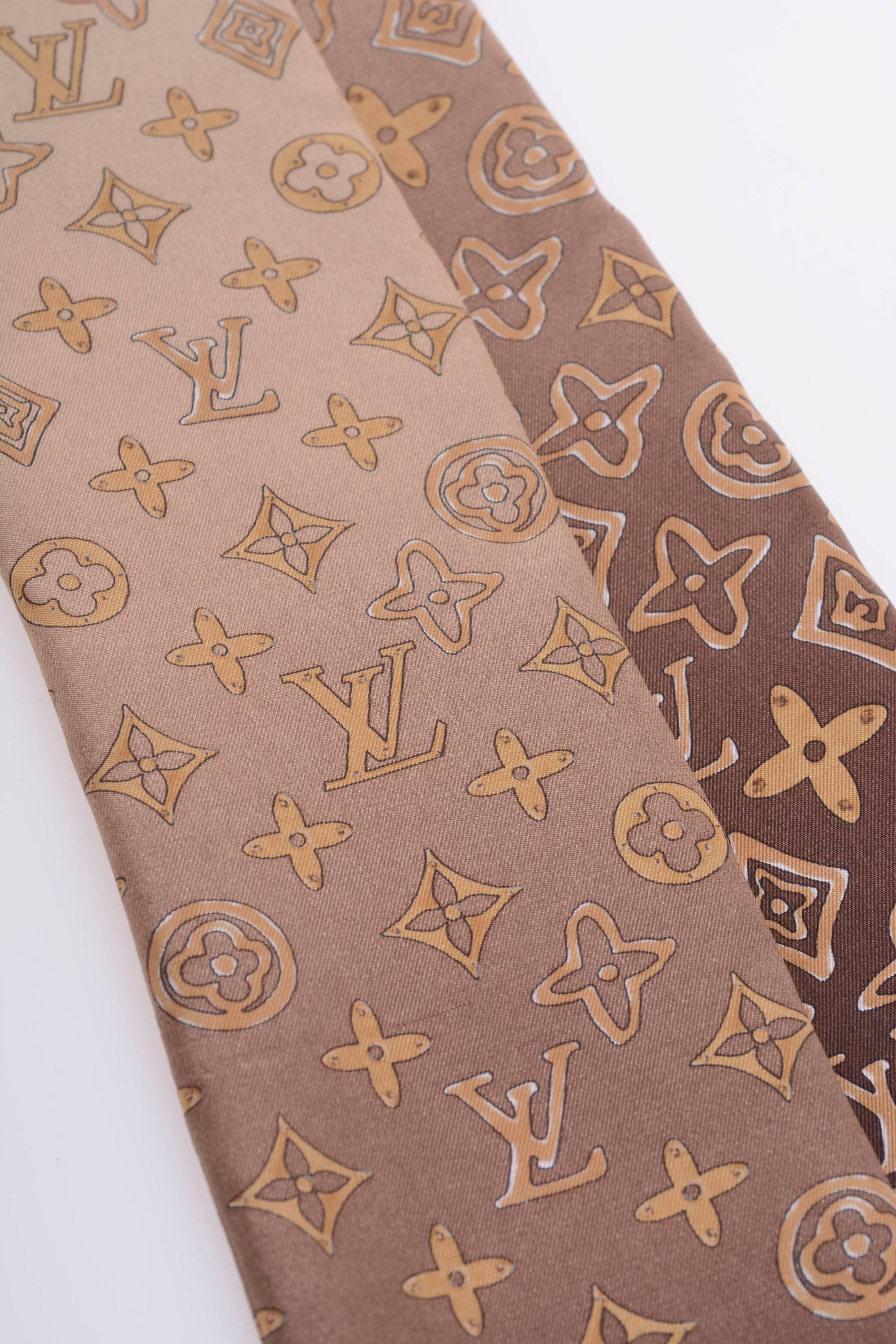 This authentic Louis Vuitton Sash Scarf is 100% silk and has typical background with LV monogram motif. 
Made in Italy

New condition with Tag

MEASUREMENTS:
3 x 47 inches