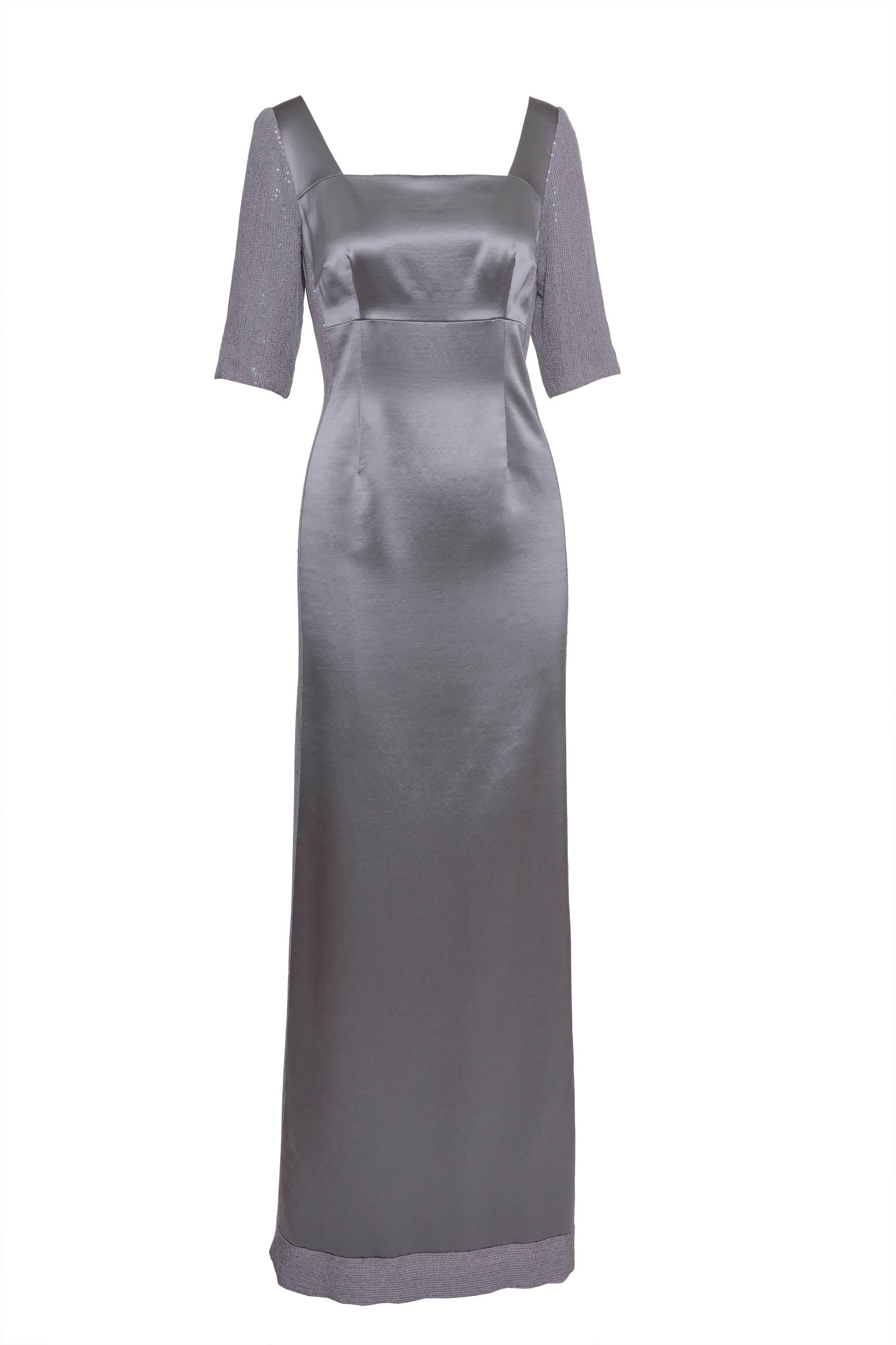 This gorgeous 1990s gray satin dress has 4 frontal darts, empire waistline, sleeves and sides embroidered, side zip closure, florentine frontal neckline and deep back neckline with 2 embroidered pieces. It has long skirt and side vent.

Excellente