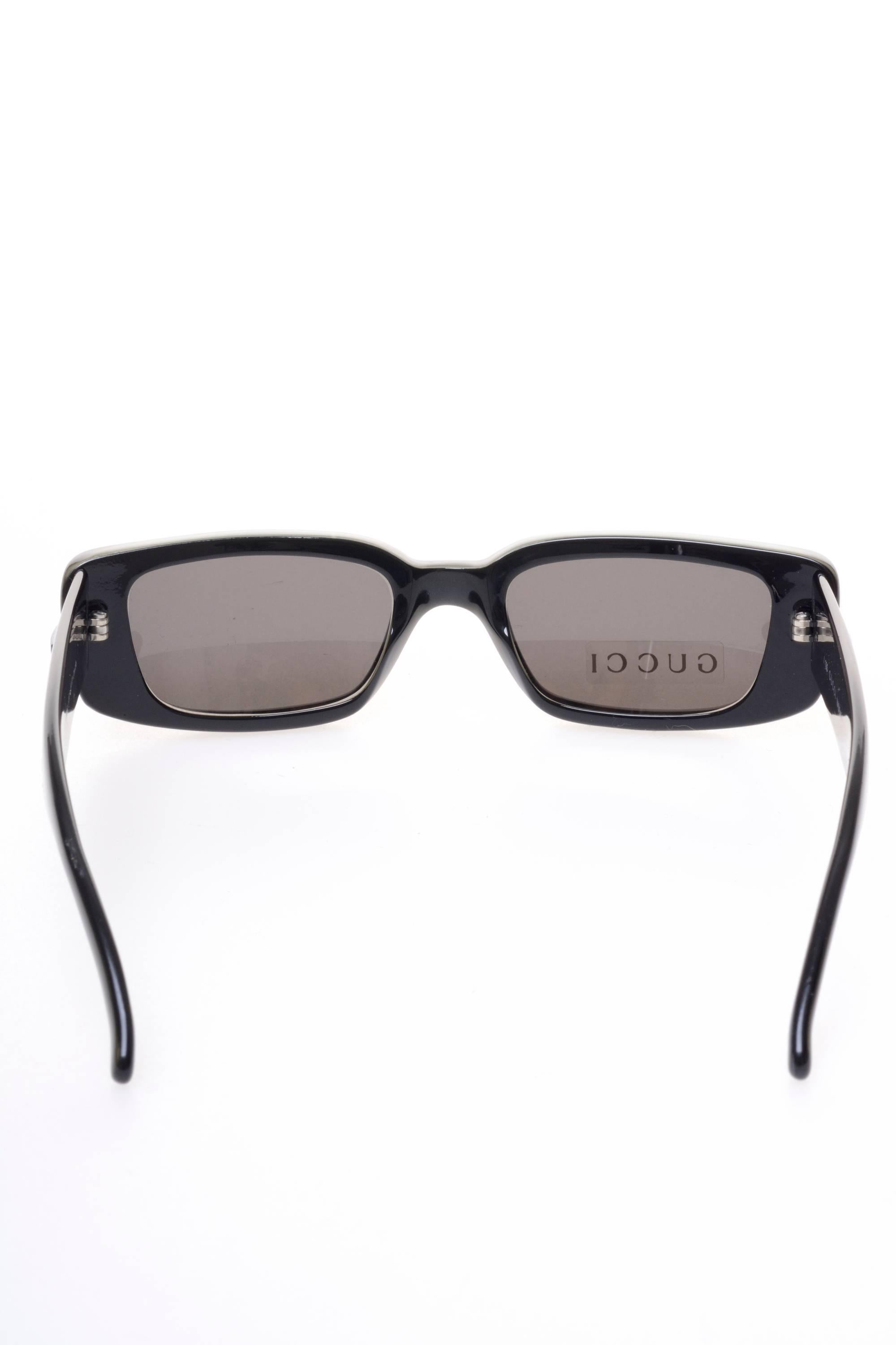 These square sunglasses by GUCCI are in a pearly green plastic with pearly black plastic details. The lenses are totally black and have a label. Made in Italy

Excellent condition   

Brand: GUCCI - Made in Italy

Measurements: 
Temple length: 5,5
