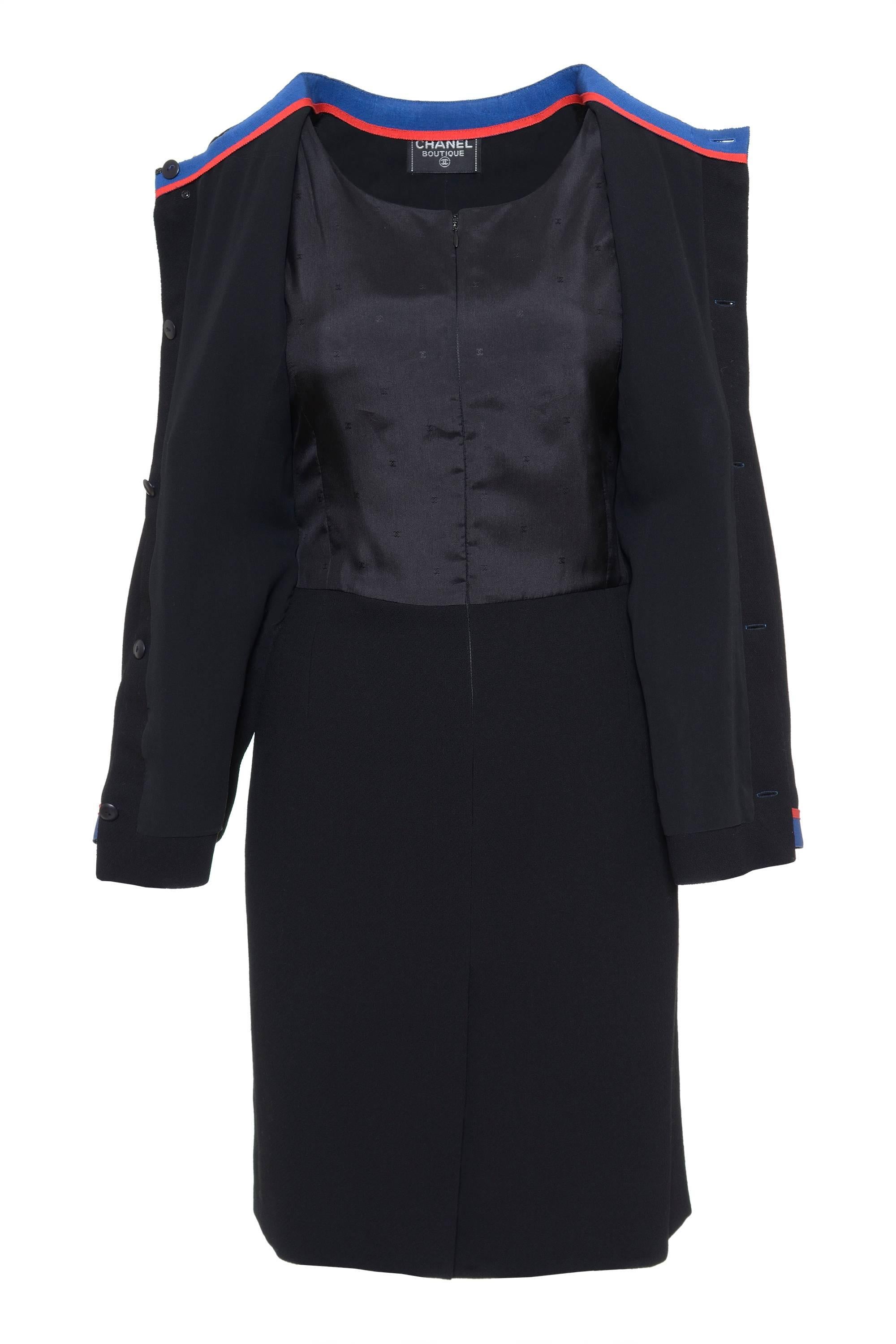 This navy style dress has a round neckline, blue and red details on the collar, pockets, jacket hems and cuffs, front gold buttons, two frontal square pockets, buttoned frontal closure, two-piece sleeves with button, pencil skirt, front and back