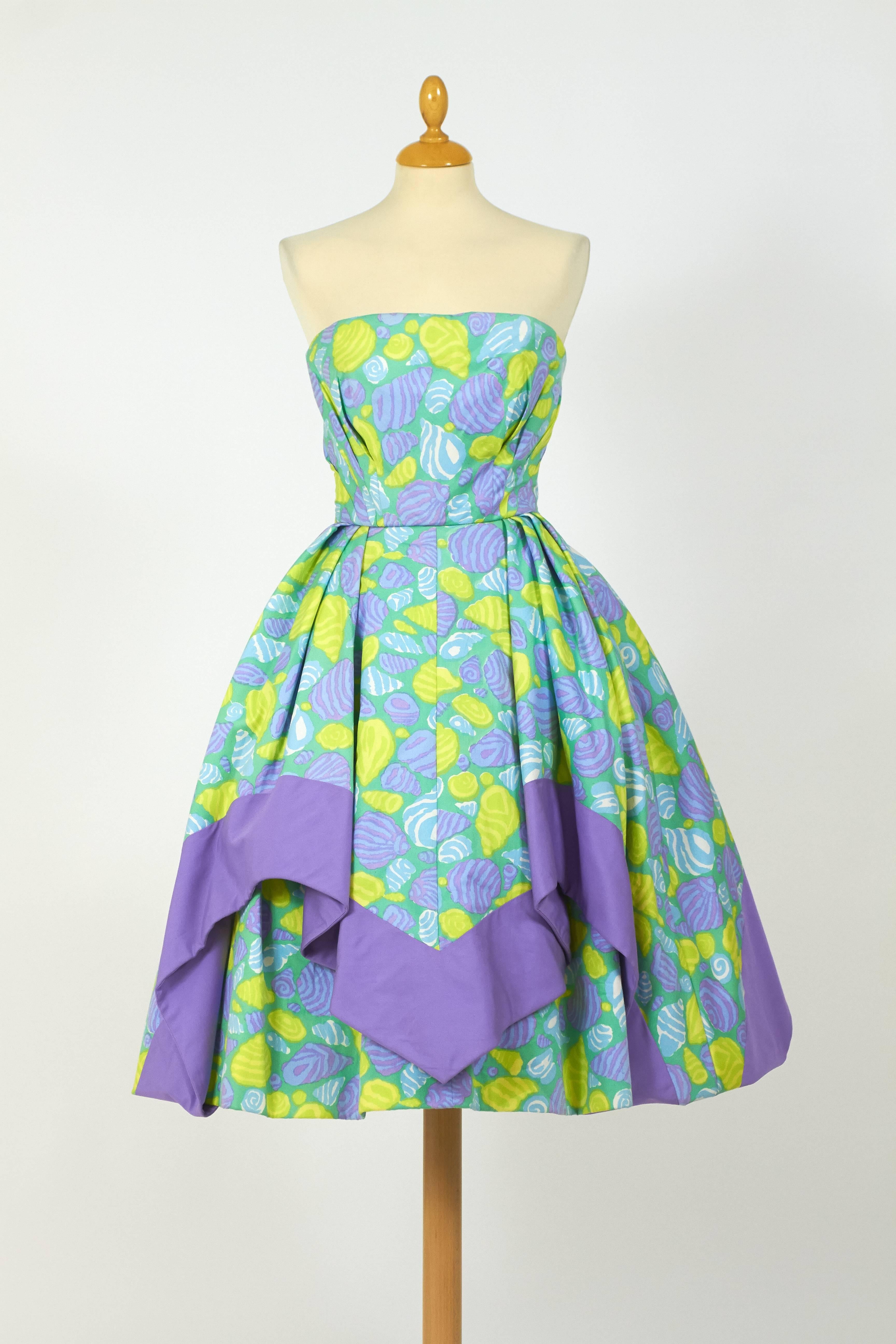 This charming 1950s italian tailor Jole Veneziani cocktail dress is in fabulous aqua green and purple novelty print shell cotton fabric. It's strapless and has a double circle skirt. The bodice is reinforced by a corset with boning and has back zip