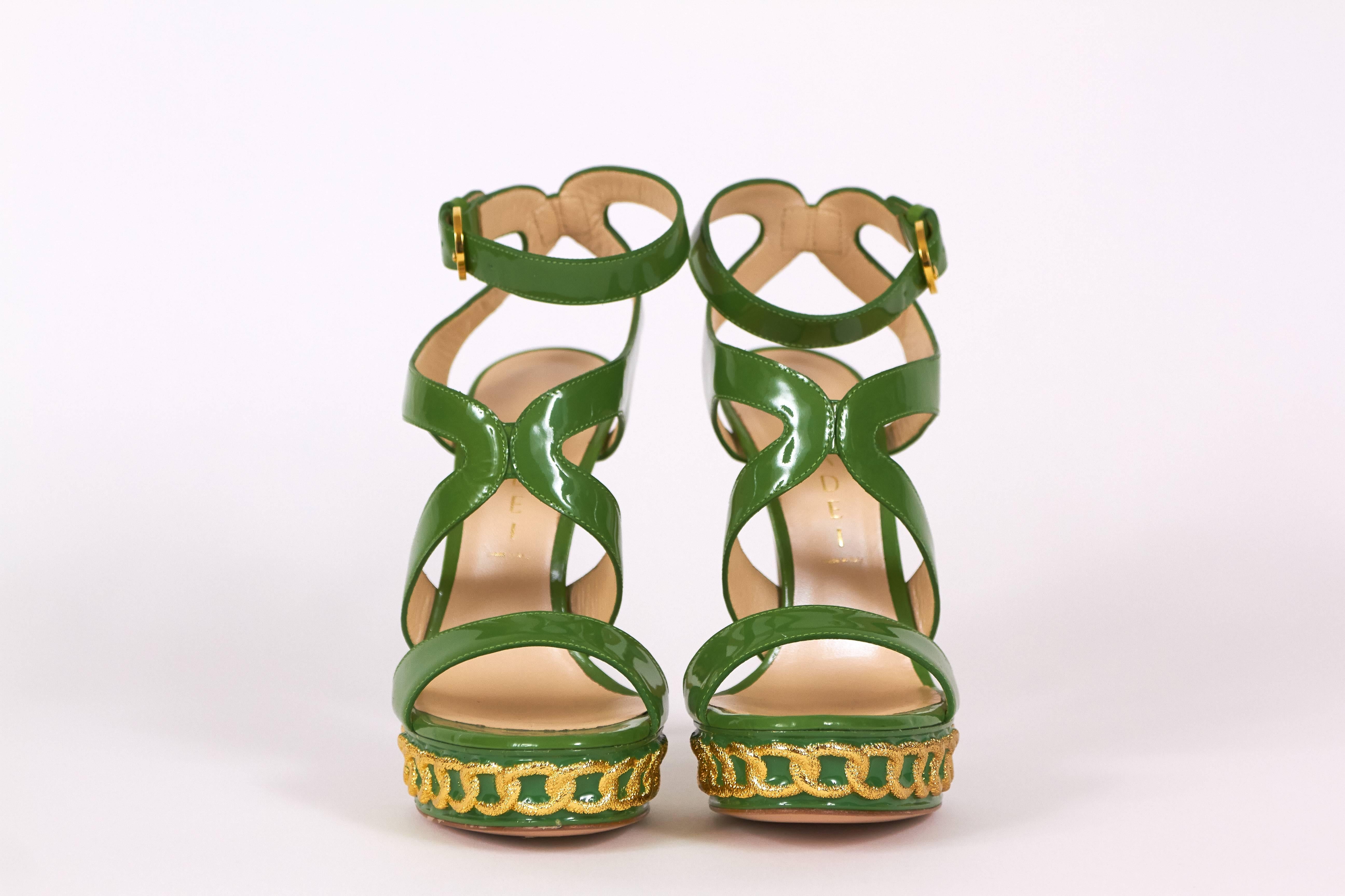 These feminine and authentic Casadei sandals are in apple green patent leather with tonal stitching, gold-tone chain-link embellishment at platforms, covered stiletto heels and buckle closure at ankle straps. 

Measurement:
Label size 36 Italian