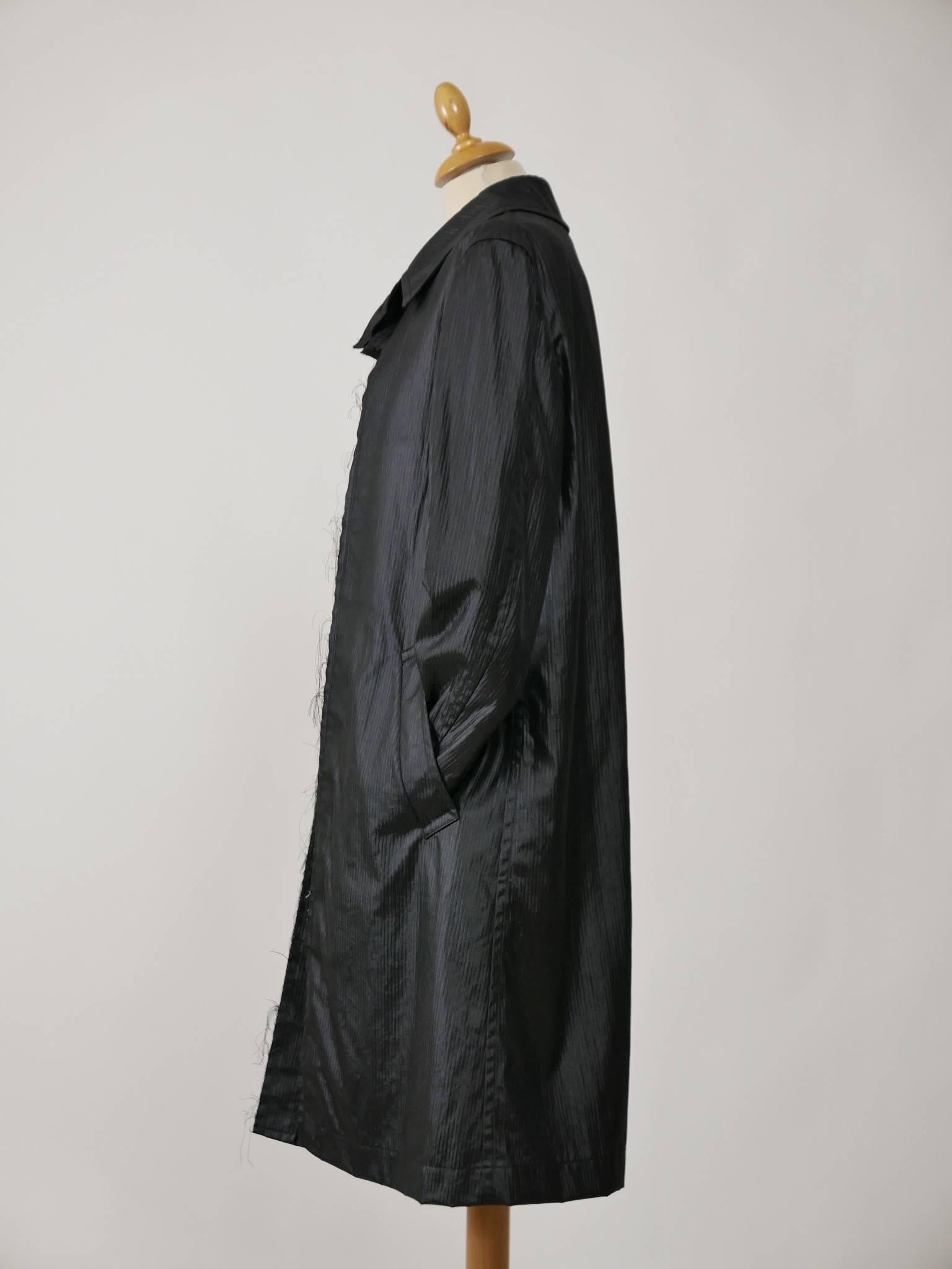 This amazing overcoat is in black striped satin fabric. It has a typical structure of the designer. 
It has side pockets and is lined with white cotton fabric.

Very good vintage condition 

Label: Comme Des Garçons  
Fabric: