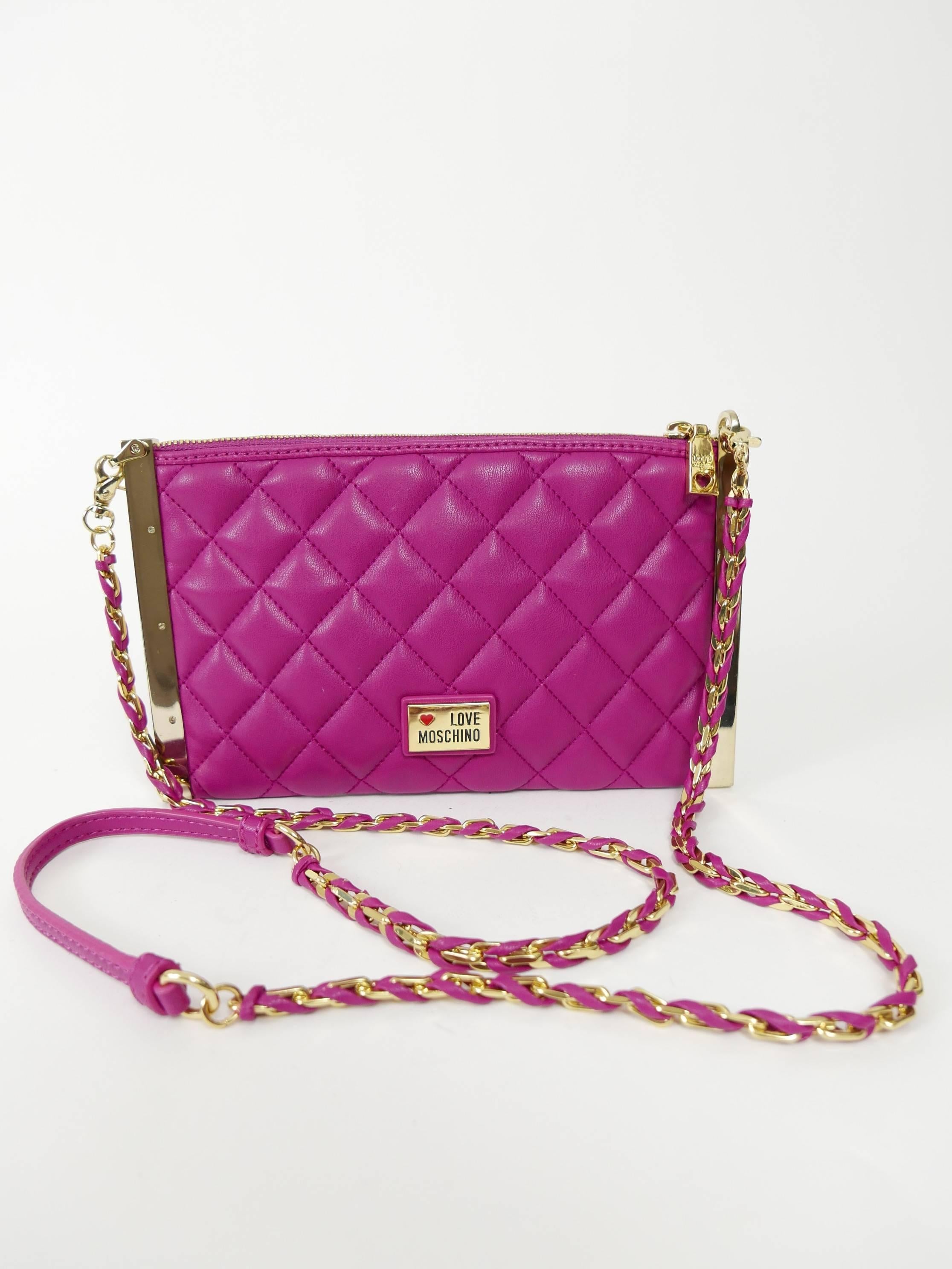 This glamourous Moschino clutch purse is in a fuchsia matelasse leather with golden metal Logo detail. It has removable shoulder strap chain in golden metal and fuchsia leather, zip closure with gold hardware, inside Love Moschino custom fabric