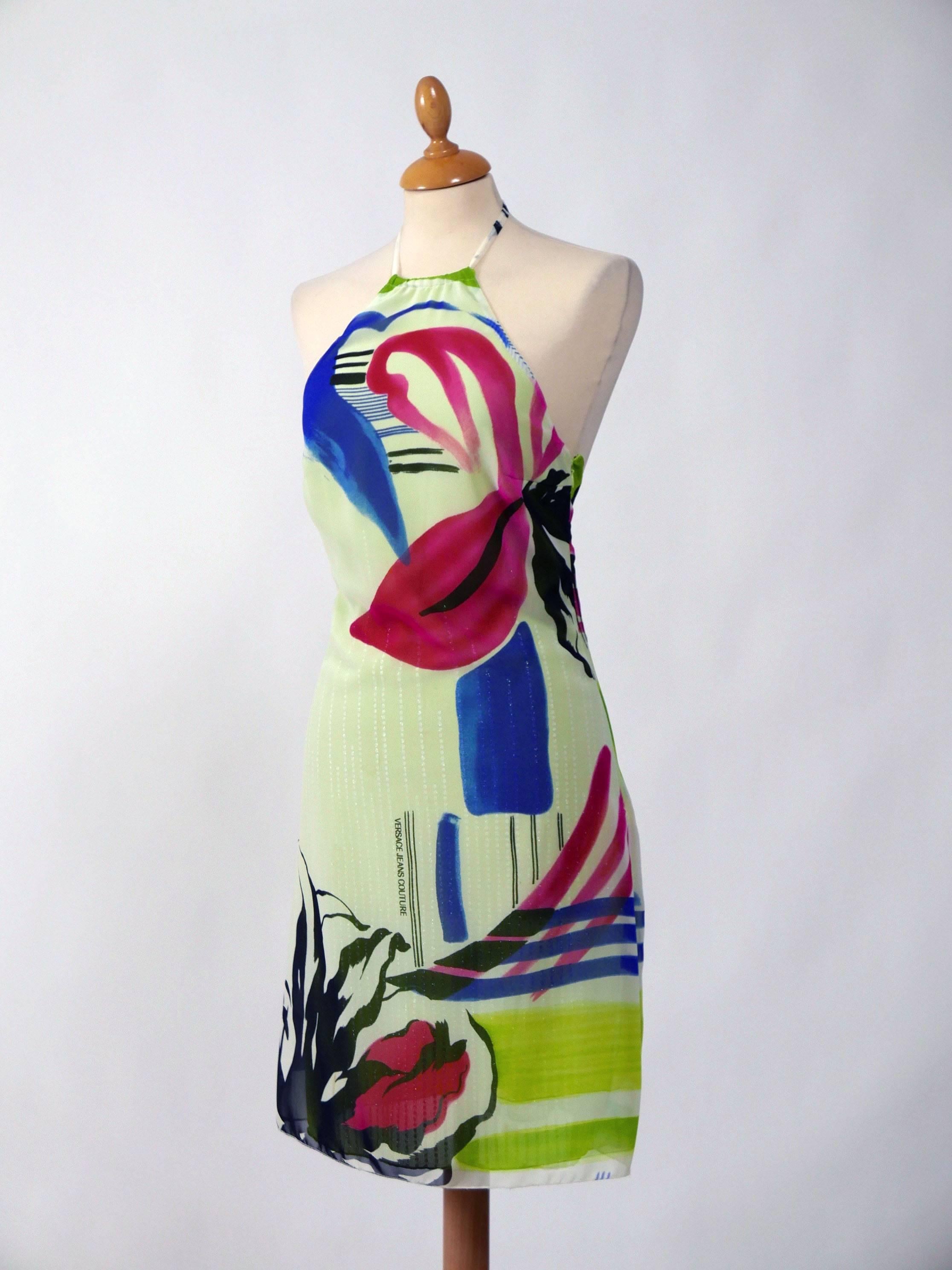 This gorgeous Versace dress is in white chiffon with floral pop art print and acid green under dress with sequins embroidered. It has side zip closure and neck straps. 

Very good vintage condition

Label: Versace Jeans Couture
Fabric: