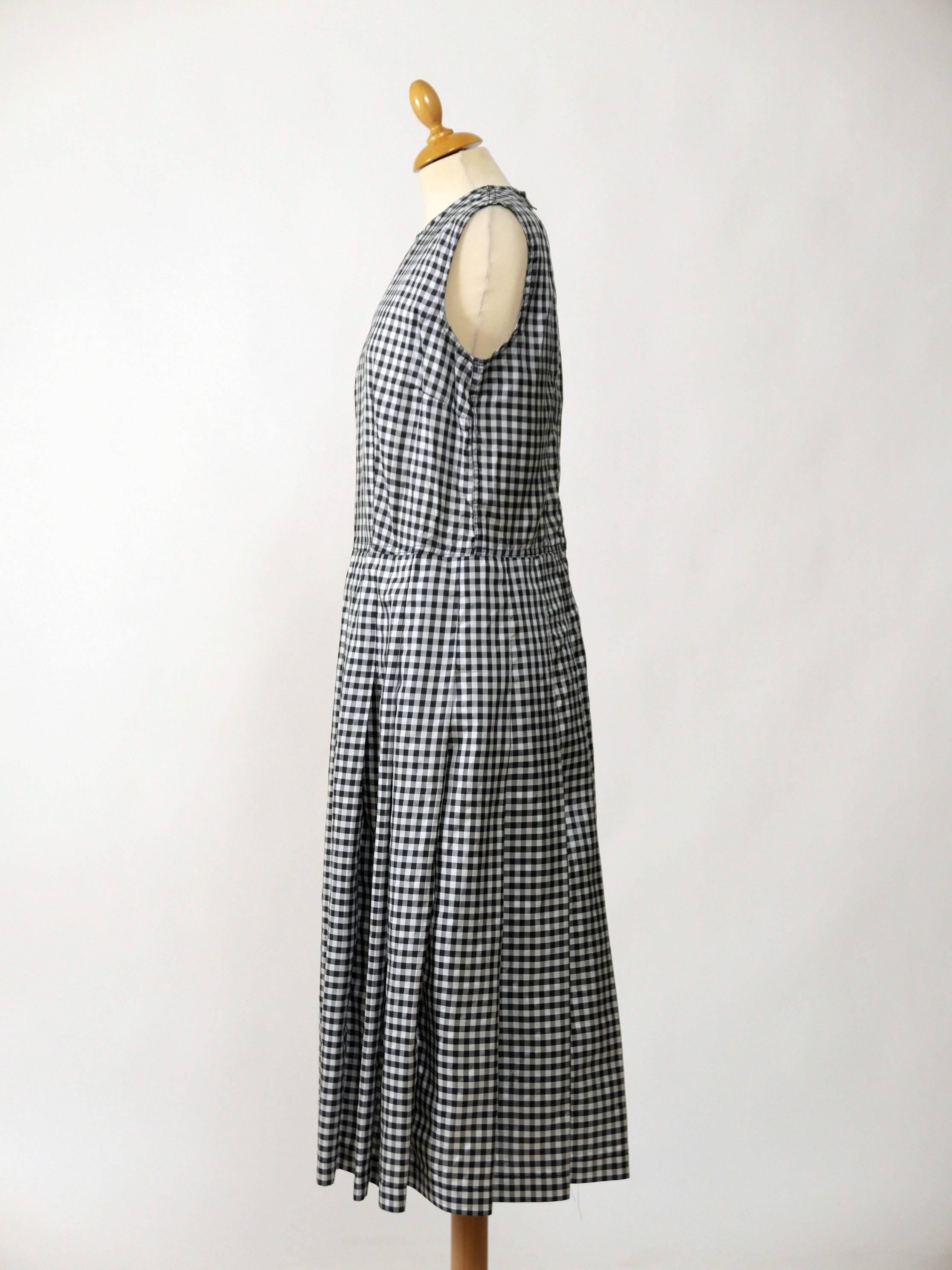 This lovely Comme Des Garçons dress is in black and white gingham print satin fabric.  It has back zip closure and pleateds skirt.

Very good condition

Label: Comme Des Garçons - Made in Japan
Fabric: polyester
Color: