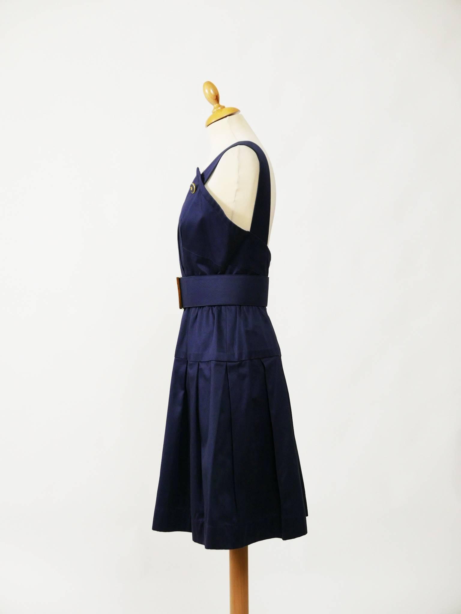 This lovely Chanel sleeveless dress is made with a navy blue cotton fabric. It has back zipper and is fully lined. It has pleateds skirt and buttons marked Chanel. It's included the belt with logo buckle.

Very good vintage condition 

Label: