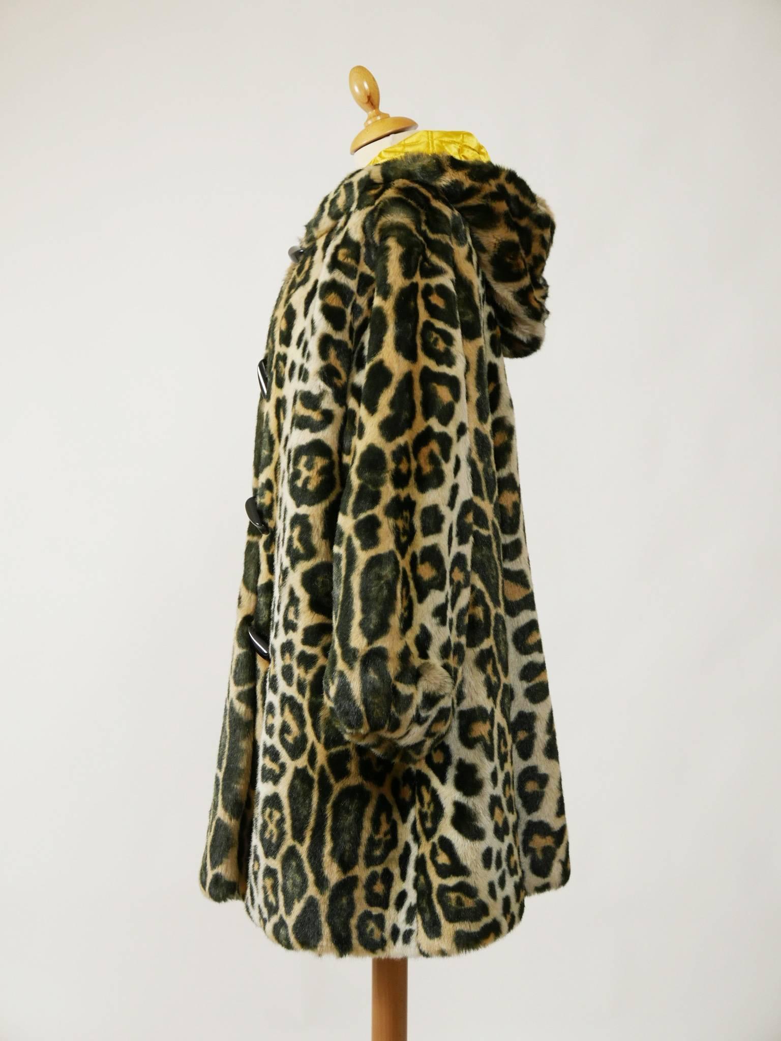 This lovely Escada 1990s coat jacket is in leopard print faux fur fabric. It has oversize line, large hood, elasticated cuffs, two side pockets and plastic buttons closure. 
It's fully lined with quilted golden silk fabric. 

Very good vintage