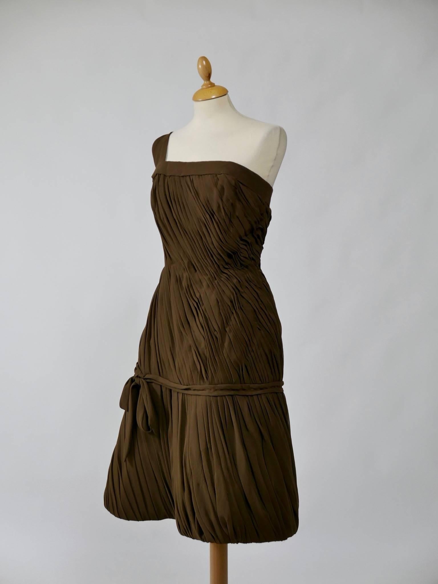 This adorable and sexy 1950s wiggle dress is in fabulous chocolate brown silk crepe fabric. It has straight neckline with one shoulder and is fully draped. Everything is lined in heavy satin fabric to give consistency to the dress. It has zip and