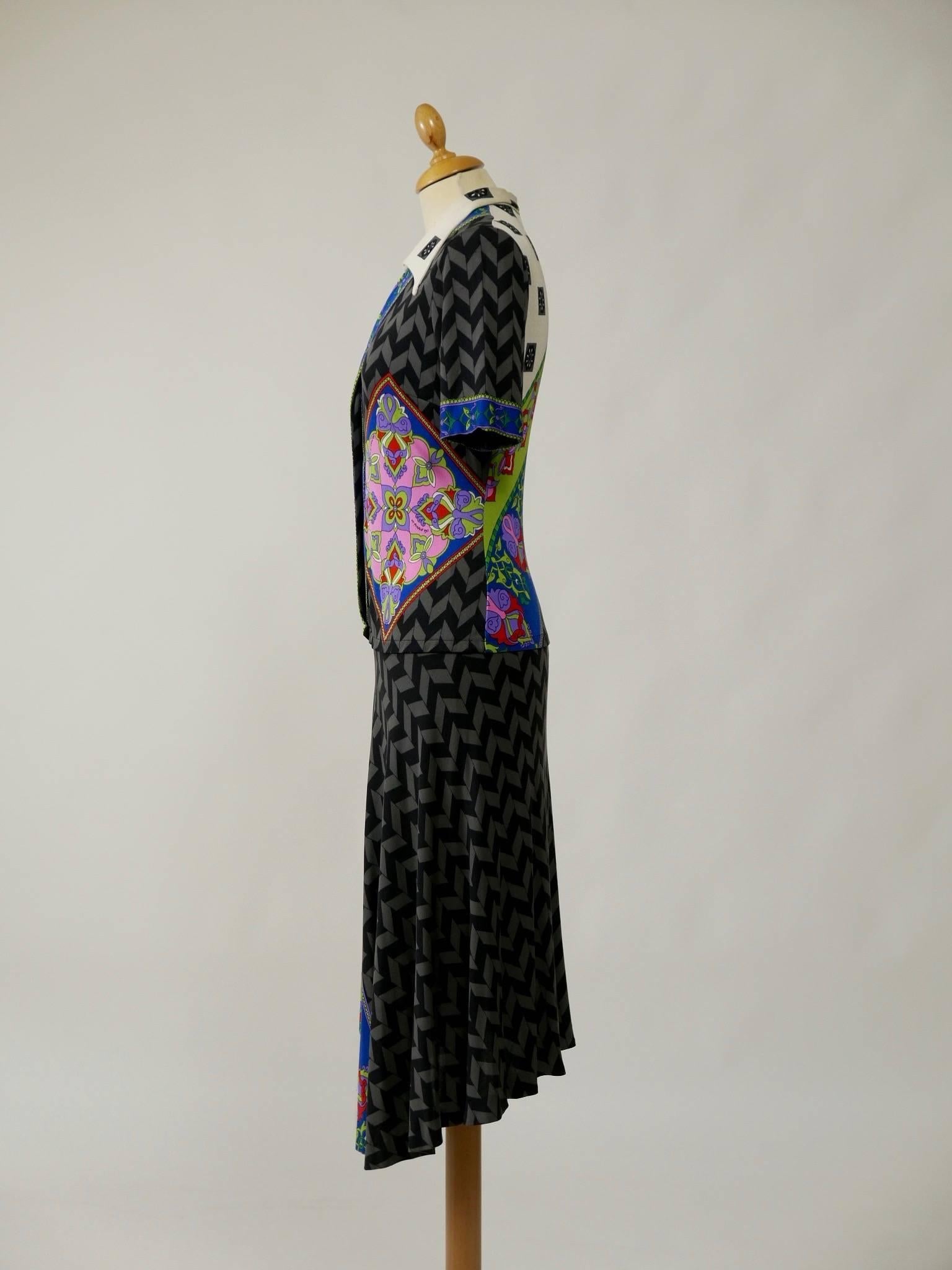 This stunning 1970s De Parisini signed dress is made of silk jersey knit. Exotic and colorful Pucci style floral print with a contrasting optical black and grey print. Collar tips and front closure with covered buttons. 

Notes: De Parisini of