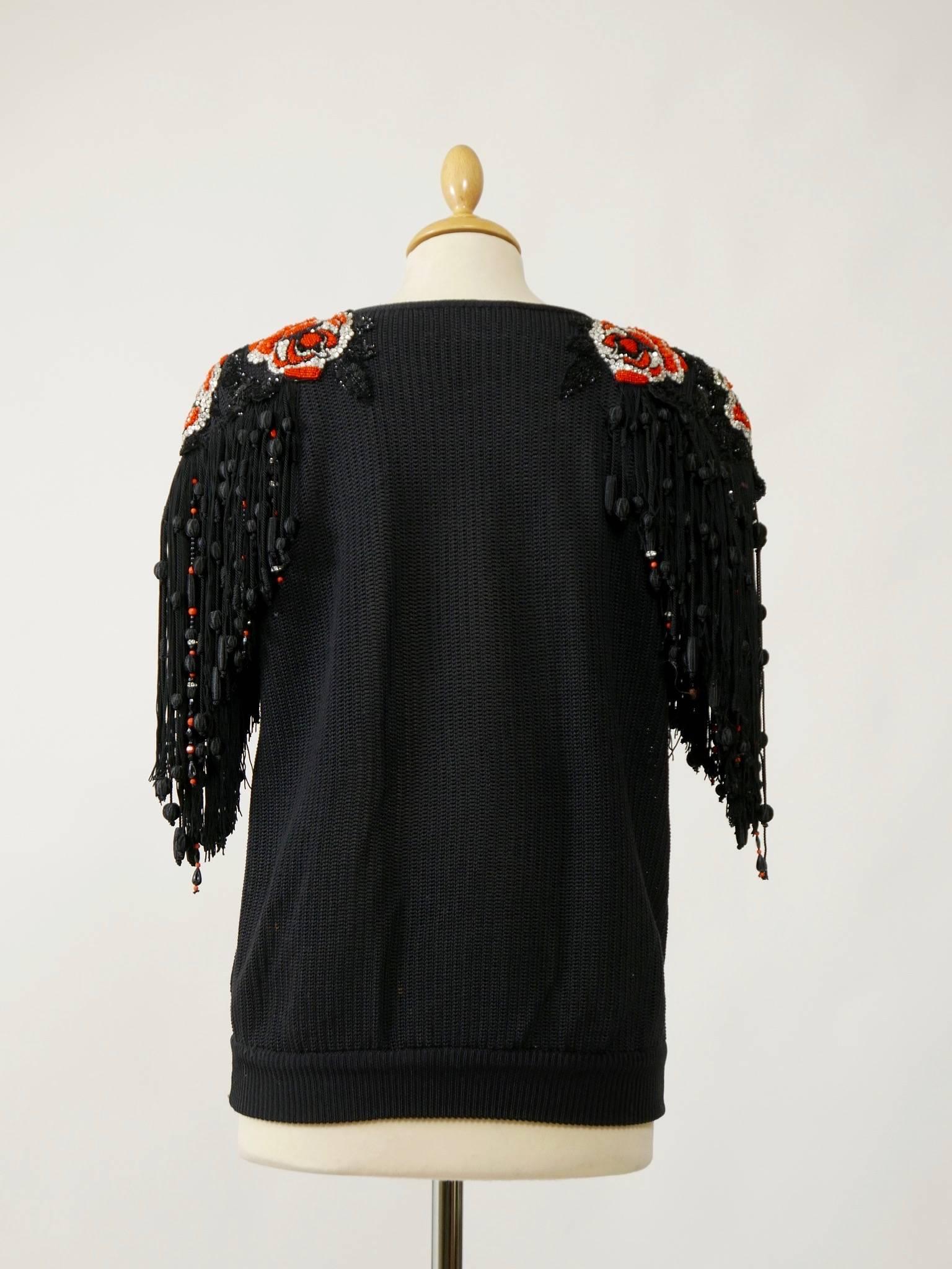 This lovely Valentino 1980s blouse shirt is in a black knitted silk fabric. It has amazing embroidered shoulder with orange beaded, black sequins, rhinestones and silk fringes.

Very good vintage condition

Label: Valentino Boutique (made in