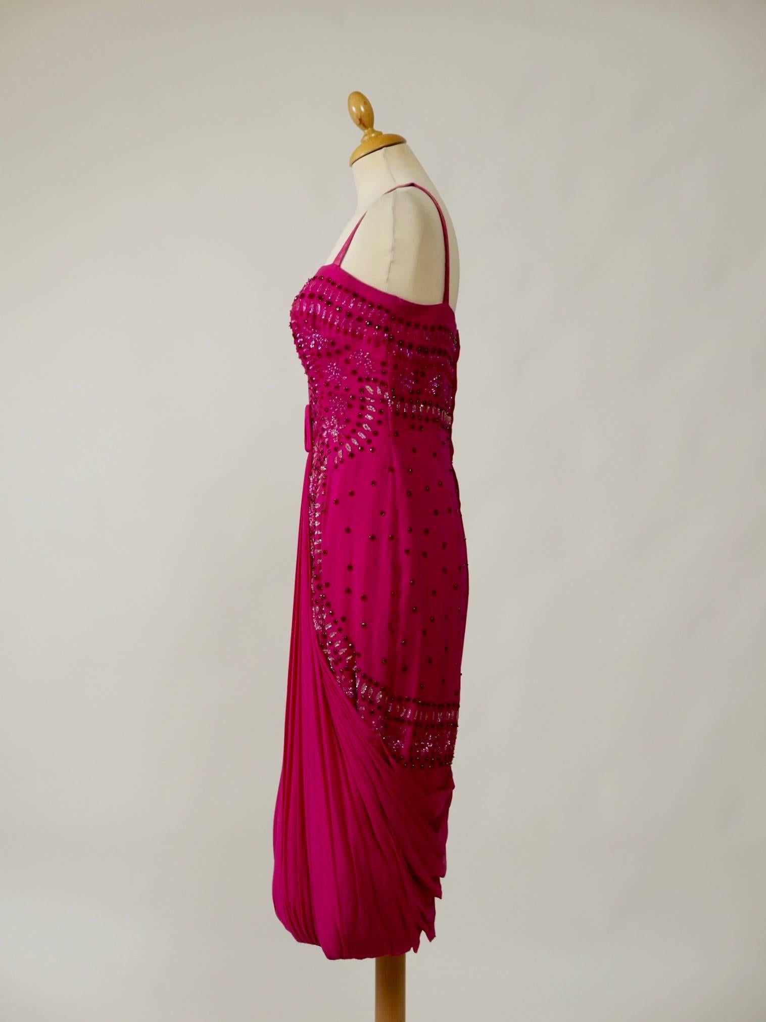 This glamorous and sexy 1950s italian tailor Giovanni Fercioni cocktail dress is in fabulous magenta silk crepe fabric with amazing embroidered glass beadeds details.  It has draped bodice and draped pencil skirt. The bodice is reinforced by a